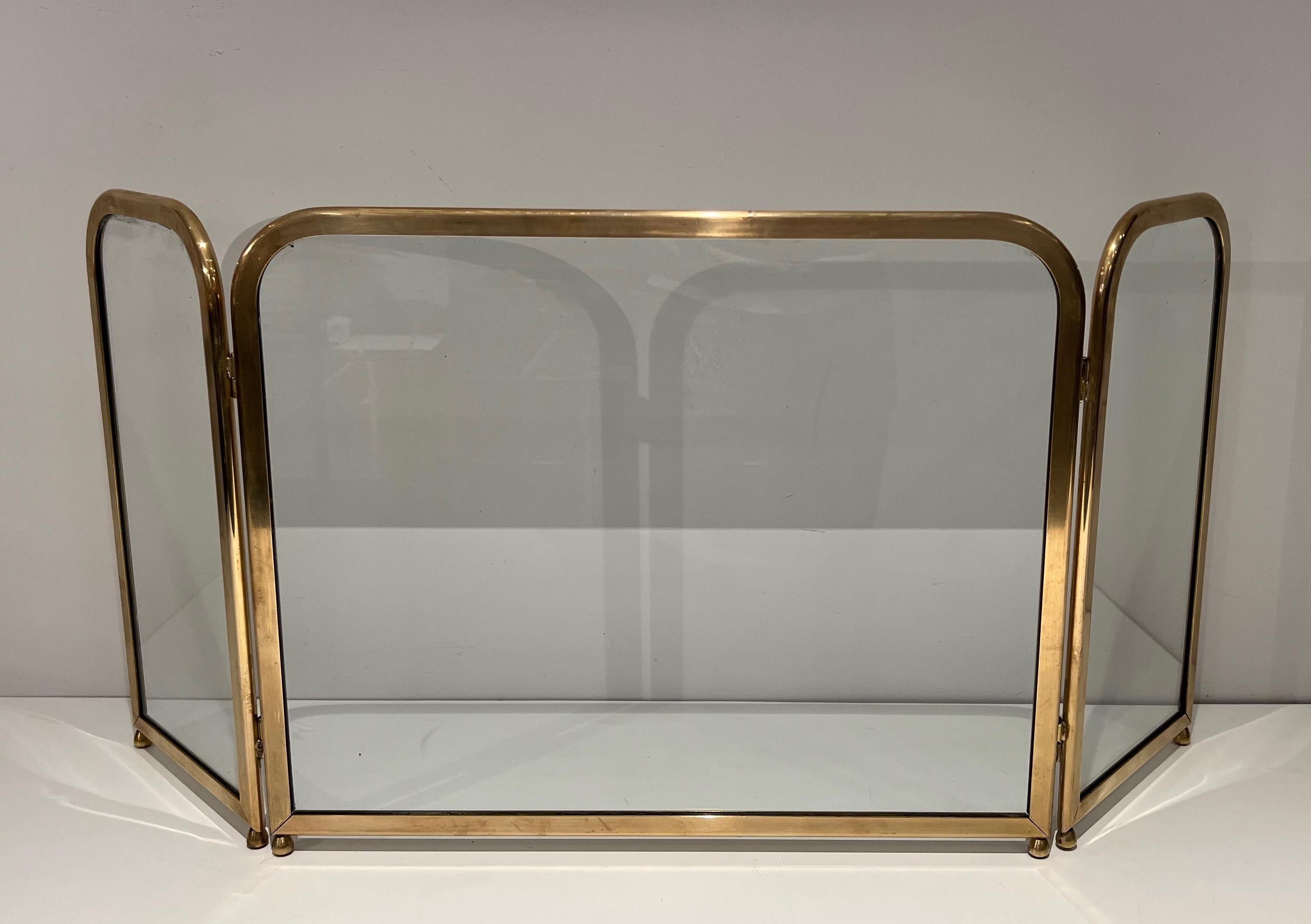 This very nice fireplace screen is made of 3 glass panels surrounded by a brass frame. This is a French work. Circa 1970