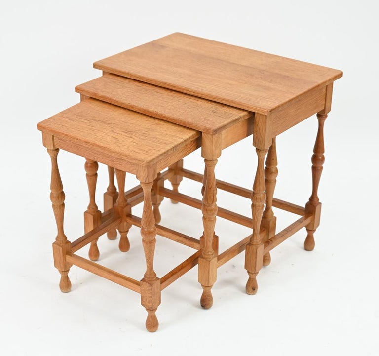 A charming set of three Danish mid-century nesting tables in carved, sturdy oak wood. Designed by Henning Kjaernulf for Odense, these model 108/EG tables are in Kjaernulf's traditional country style, an unusual subset of Scandinavian design for the