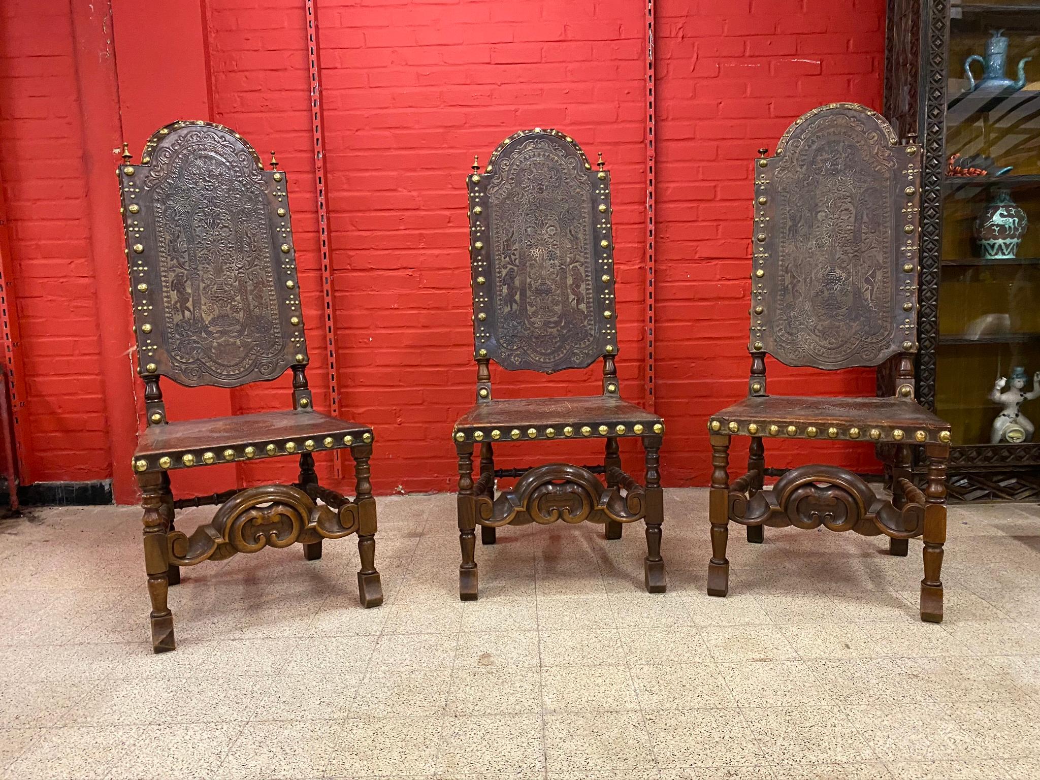 3 high-backed chairs, Cordoba leather trim with Native American decor and cupids framing a floral arrangement.
Ornamentation of copper cabochons on the border.
Spain 19th century.
Provenance: Chateau de S ..... (center of France)
small wear and