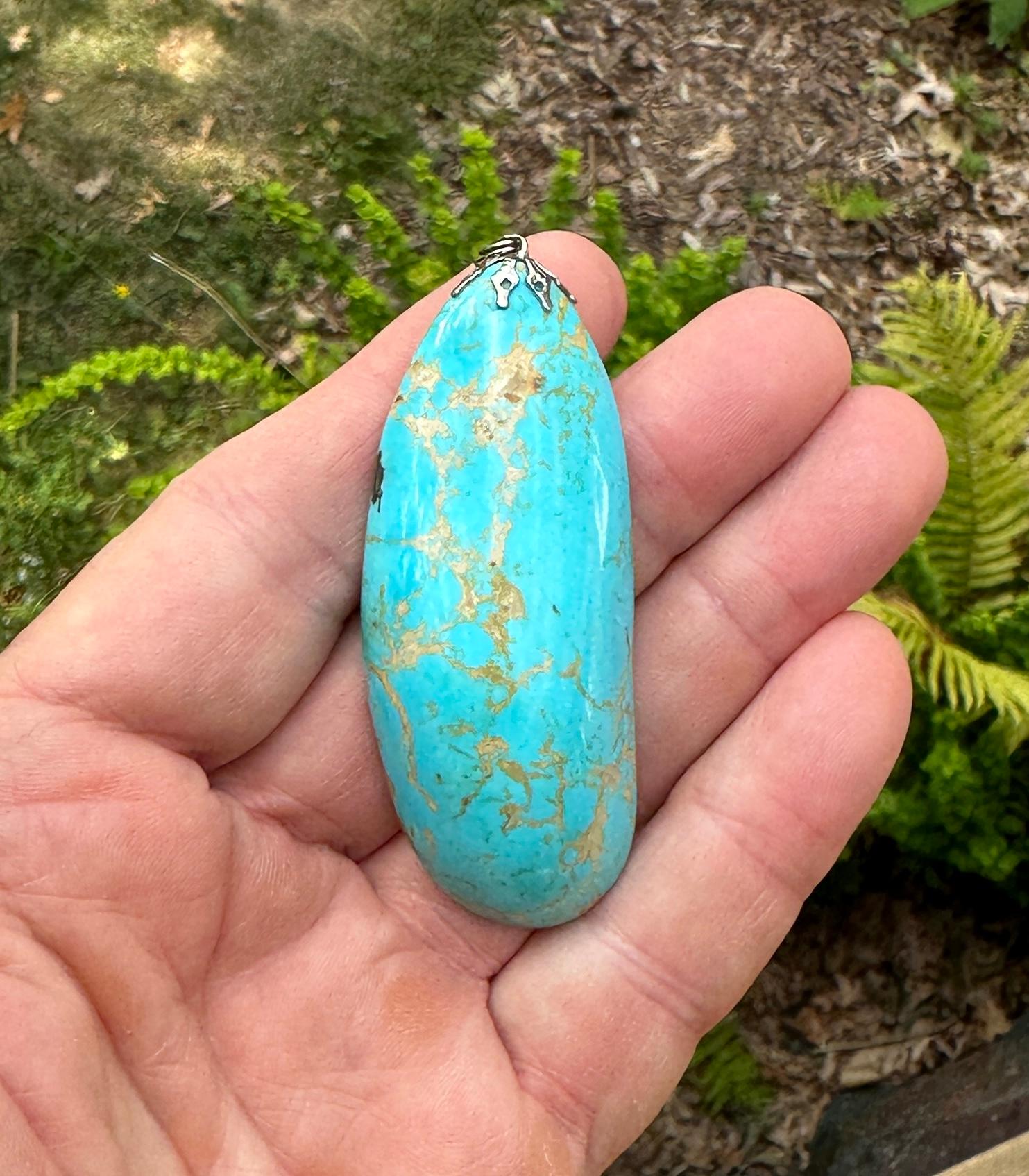 This is a stunning monumental Turquoise pendant set in Silver.  The natural mined Turquoise is 2 7/8 inches in length and is 1 1/4 inches wide.  The turquoise has gorgeous blue color with fabulous matrix.  It is polished to a smooth surface which is