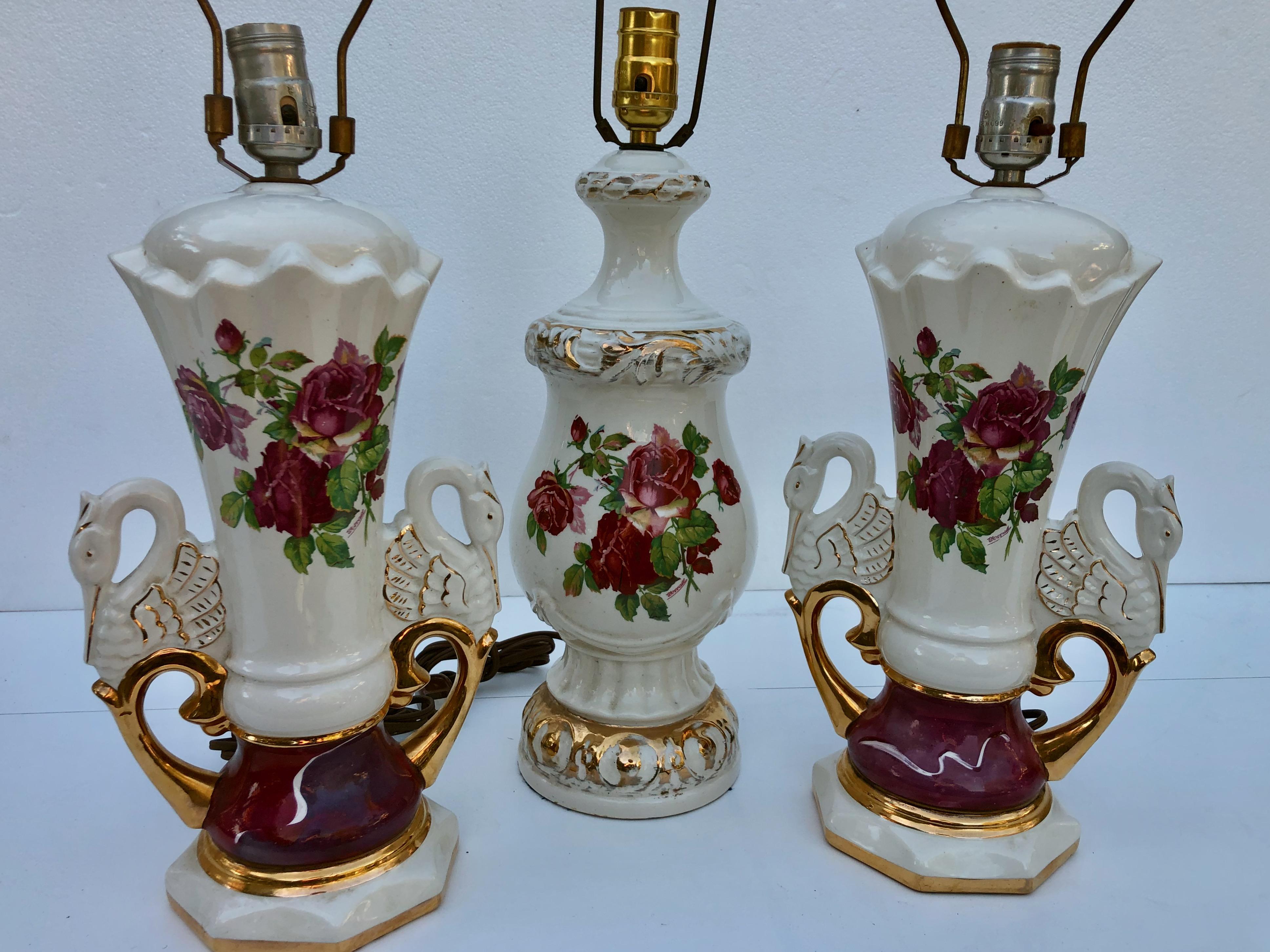 This is a lovely set of three Jenny Worall hand painted ceramic table lamps. Two of the lamps are a matched set with swan handles and all have a rose floral motif painted in shades of pink with gold trim.

Matching swan handle set: H 16.5 x W 7.5
