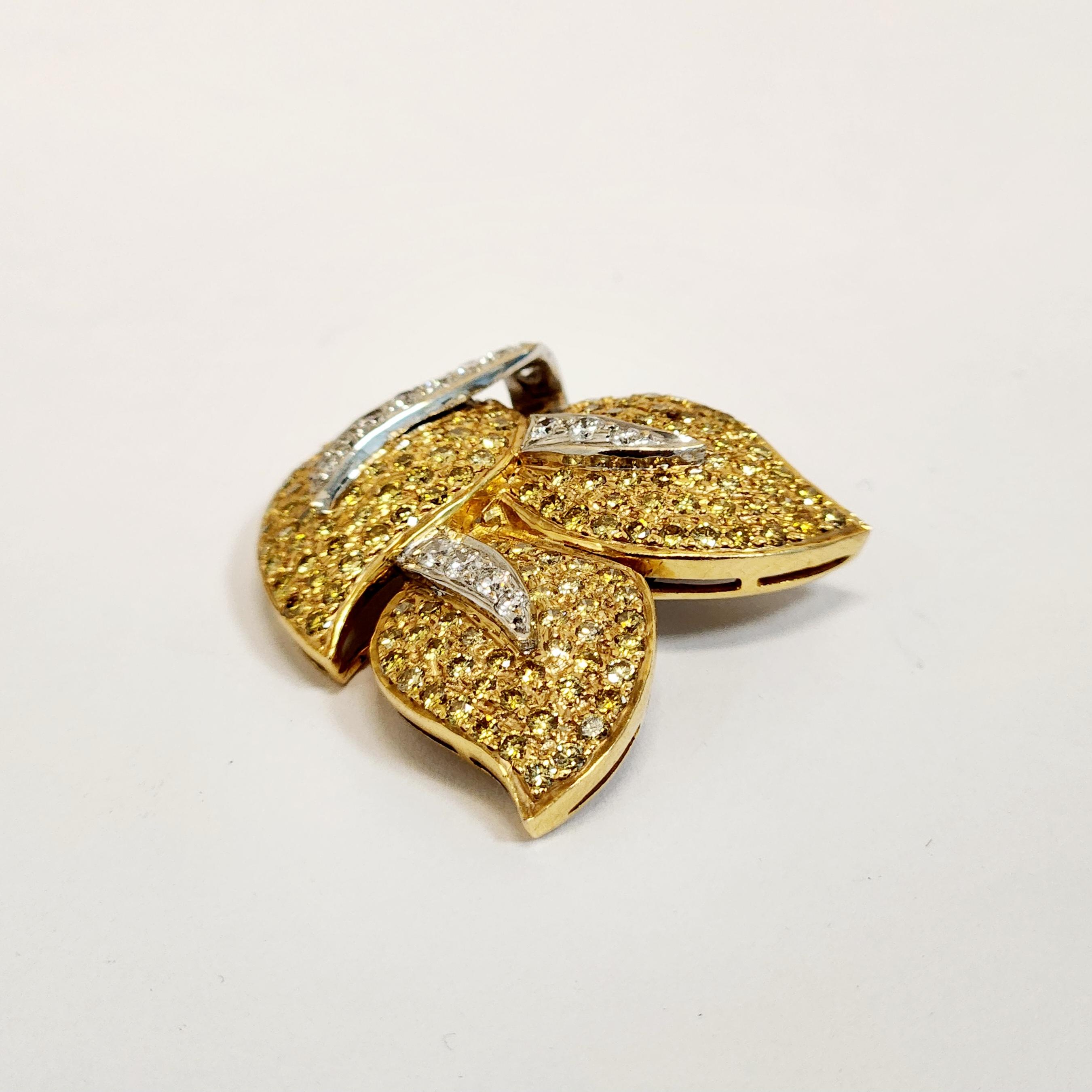 This exquisite pendant features a beautiful design of three leaf shapes crafted with sparkling yellow diamonds, complemented by stems of round white diamonds. The pendant is set in a stunning combination of 18K white and yellow gold, adding to its