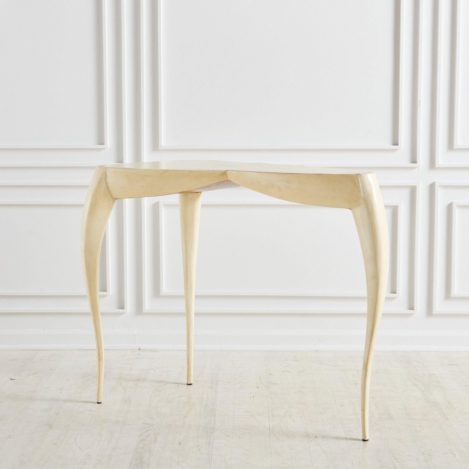 A gorgeous French modern console table by R&Y Augousti, Paris. This table was constructed with wood clad in shagreen leather sheets and features organic shapes and three curved legs. Ria and Yiouri Augousti are known for their revival of artisanal