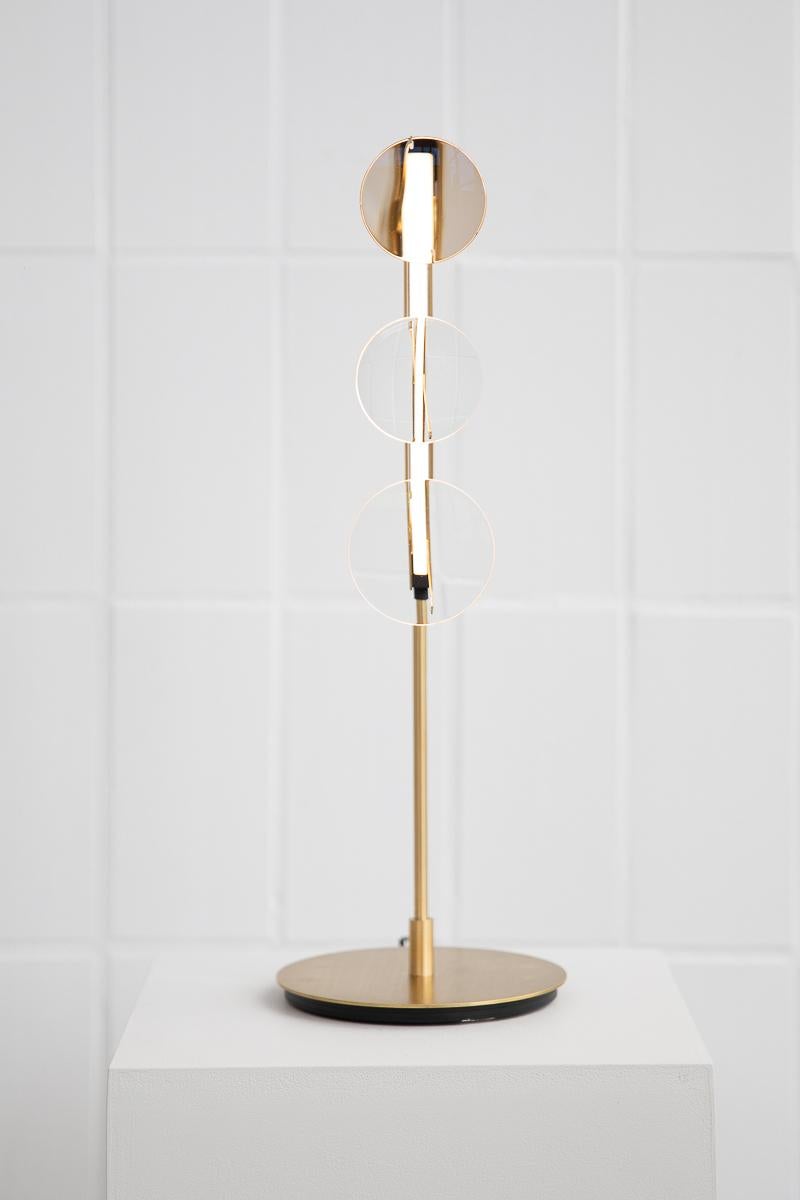 3-Lens table lamp by Object Density
Handmade
Dimensions: Ø16 x 48 cm
Material: Brass (Messing), Optical lenses, Dimmable 12V LED

Through a close inquiry into an optician’s process and production, Object Density have realised the opportunity to