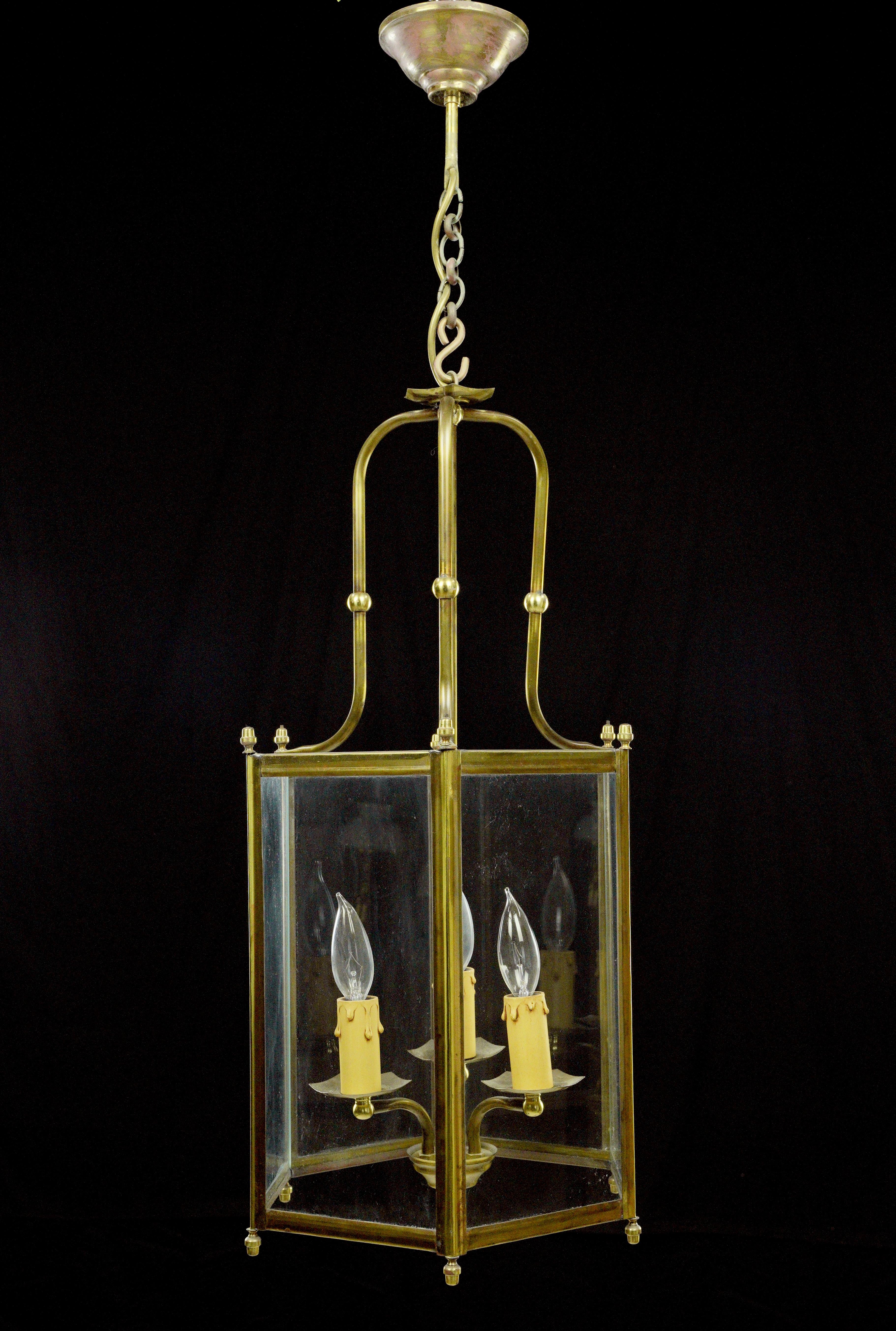 This Traditional pendant light features a hexagonal lantern design, made from brass and glass, with three arms. This piece was acquired from an estate located in Greenwich, Connecticut. The price includes restoration of cleaning and rewiring. This