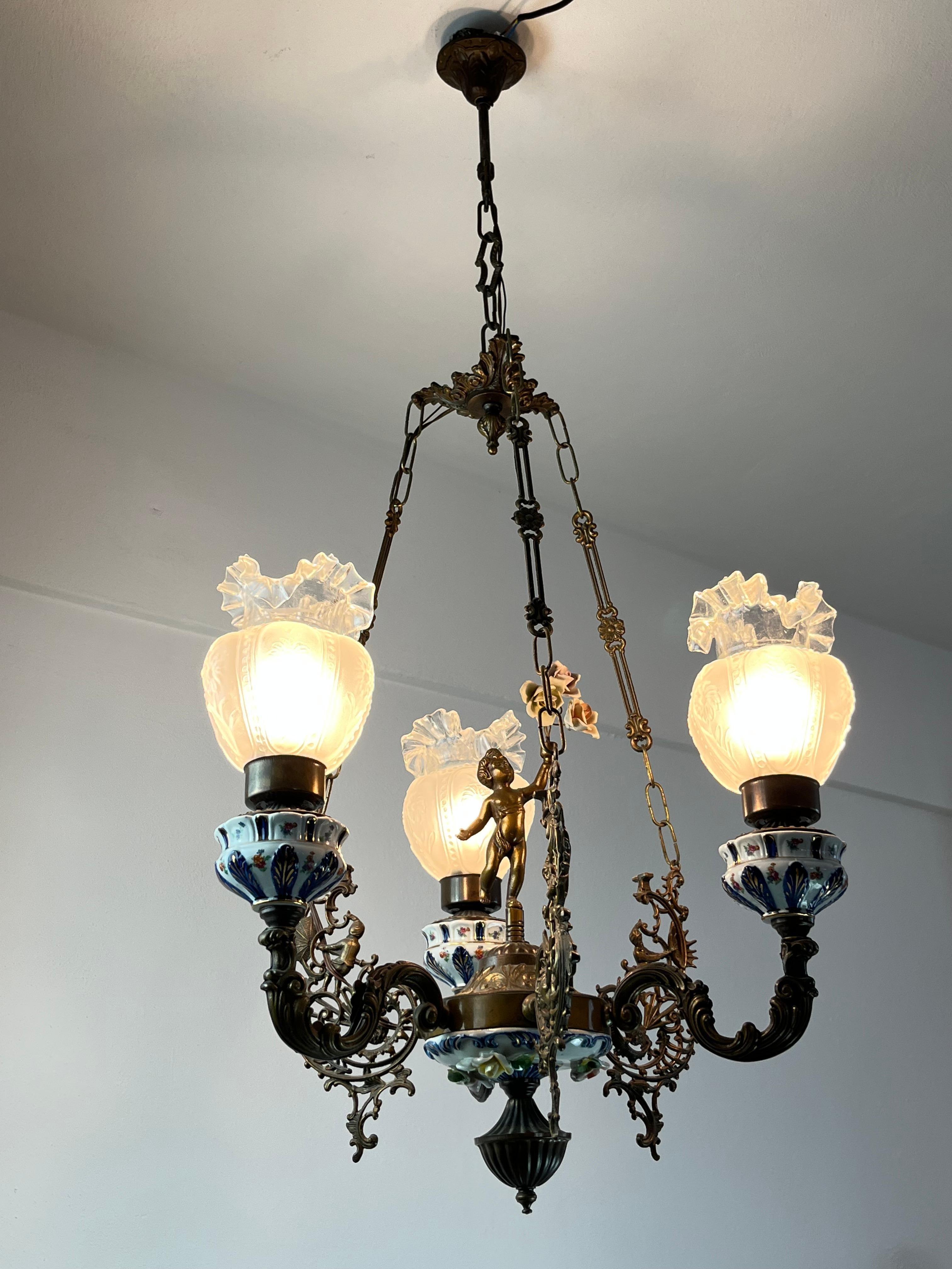 Lustre à 3 lumières en bronze, porcelaine et Capodimonte, Italie, années 1940
Trouvé dans un appartement noble.
Trois bols en verre festonnés.
Il est en excellent état si l'on considère qu'il a presque 100 ans. Connexion de la lampe E14.