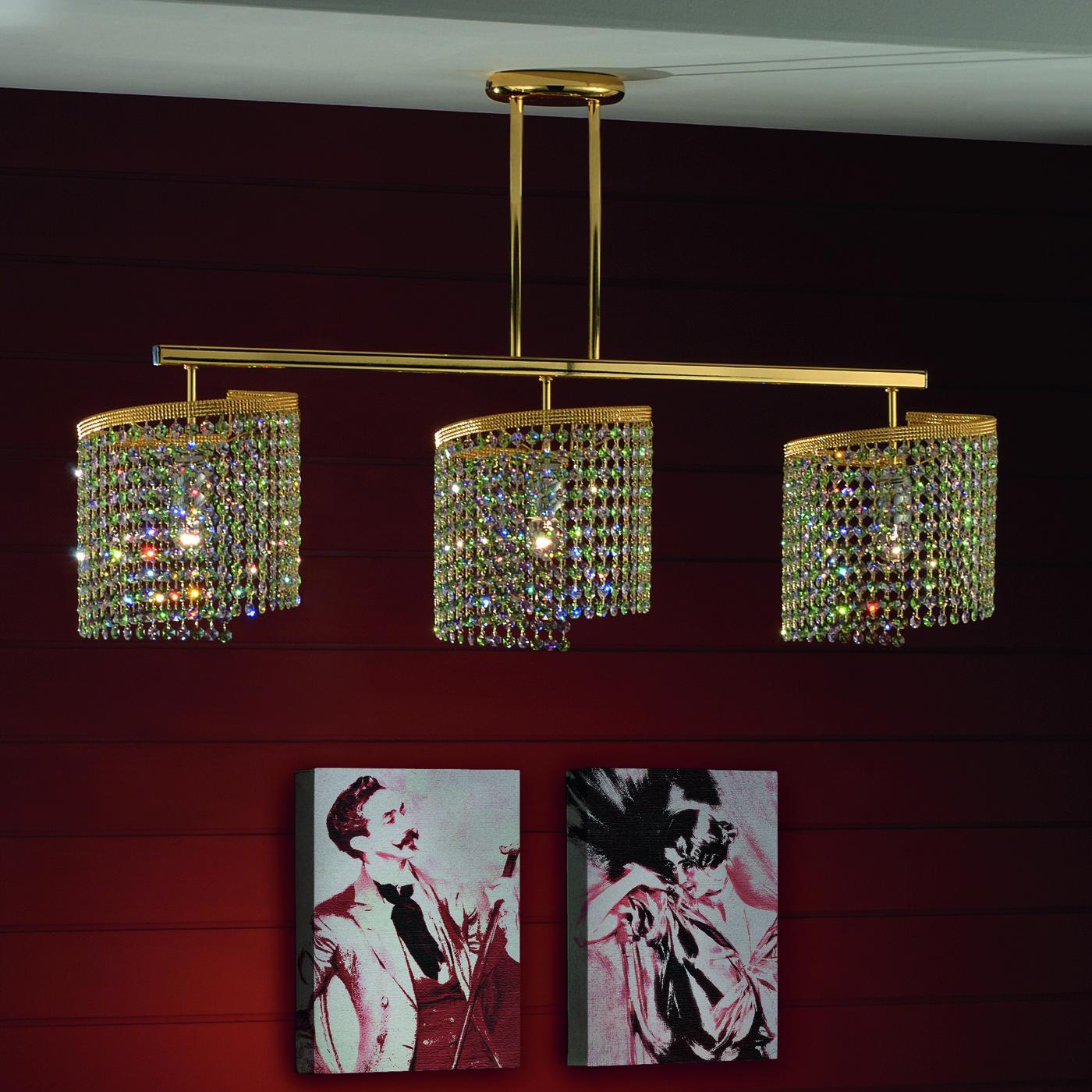 Natural and artificial reflections catch the eye of those who enter a room illuminated by this piece. This three lights chandelier, made of glass with precious sparkling gold inserts, certainly steals the show. A gold-colored rectangular base