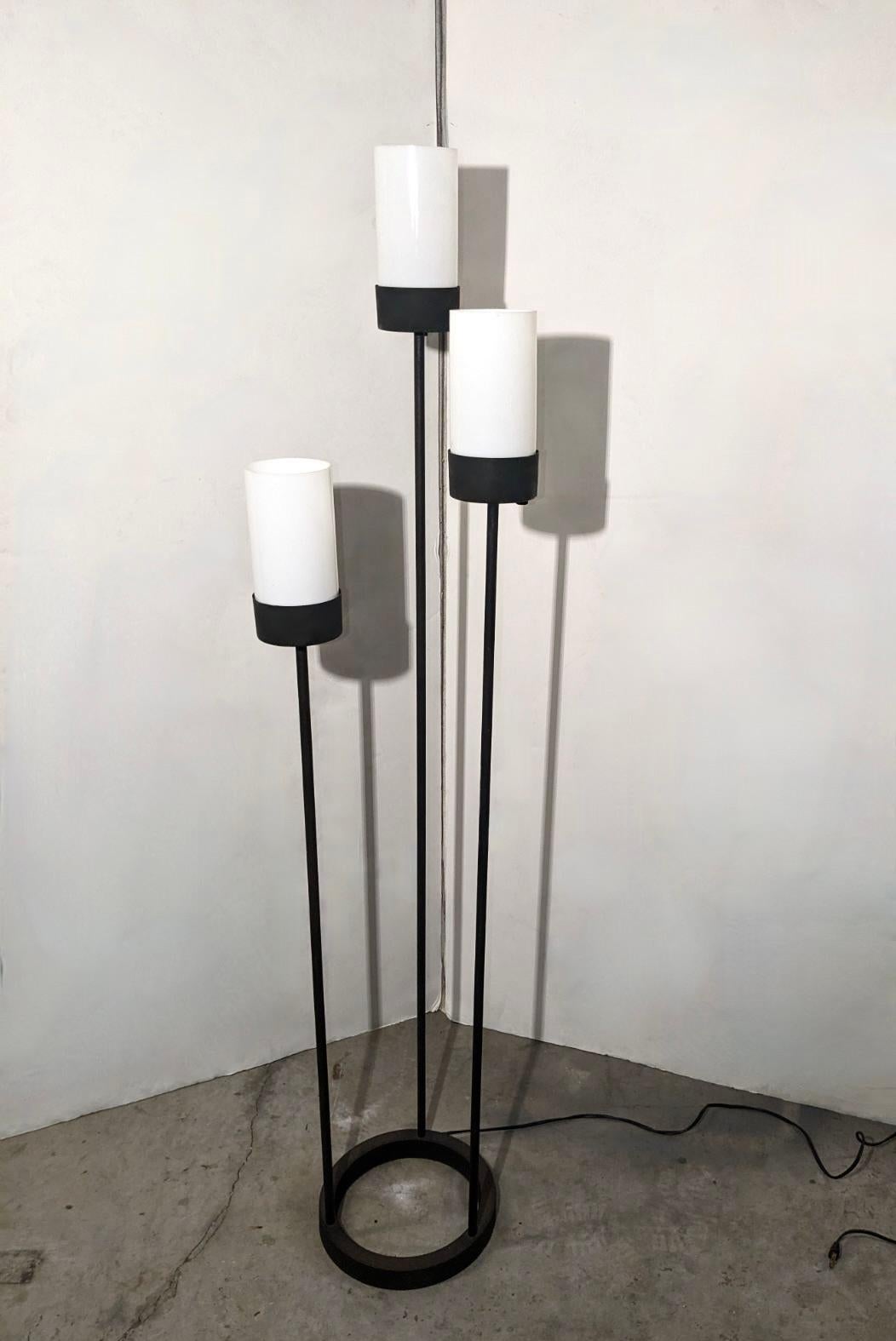 Lámpara de pie de 3 luces diseñada por Robert Bulmore en hierro esmaltado negro con pantallas cilíndricas de vidrio blanco opaco. Cada luz se controla mediante un interruptor de encendido/apagado independiente. 