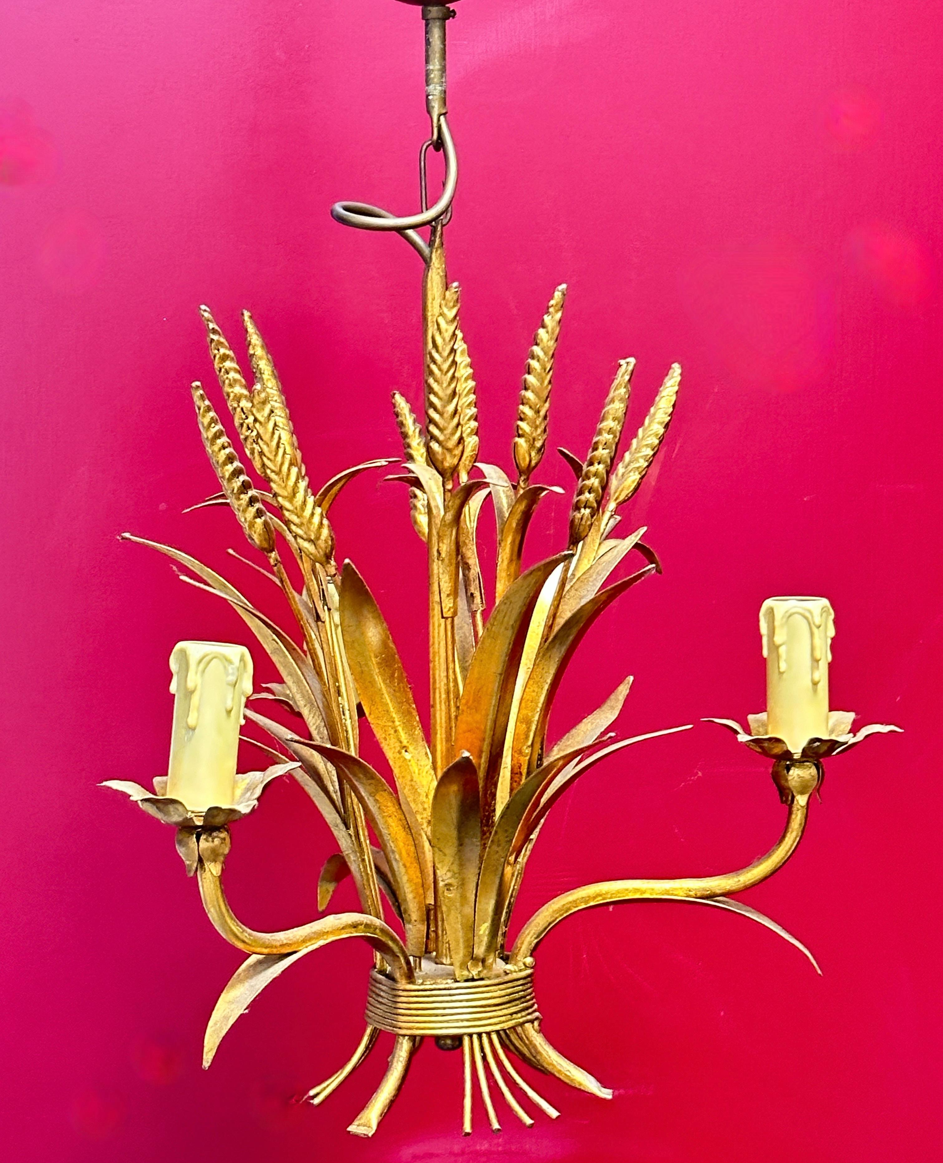 A Hollywood Regency midcentury gilt tole wheat sheaf chandelier in Coco Chanel Style, the fixture requires three European E14 candelabra bulbs, each bulb up to 40 watts. This light has a beautiful patina and gives each room an eclectic statement.