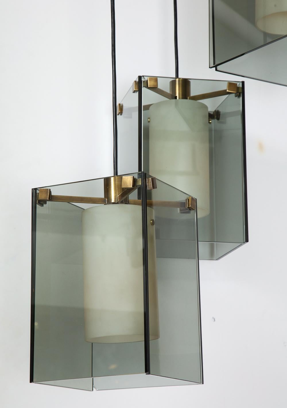 Model #2210, 3-light pendant. Smokey-gray glass panels with frosted-glass cylindrical shades. Each shade conceals one standard size Edison socket. Oxidized brass mounts & ceiling plate. Drop height of each pendant can be adjusted. *small chip to one