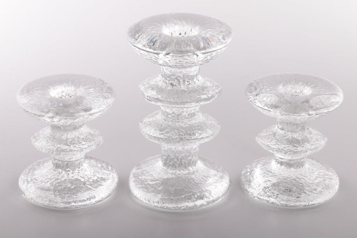 3 Littala Festivo Candle Holders Designed by Timo Sarpaneva

A beautiful glass object from Scandinavia: signed Iittala festivo candlestick candle holder with 1 ring design by Timo Sarpaneva from 1966. 
Timo Sarpaneva (1926-2006) was one of the