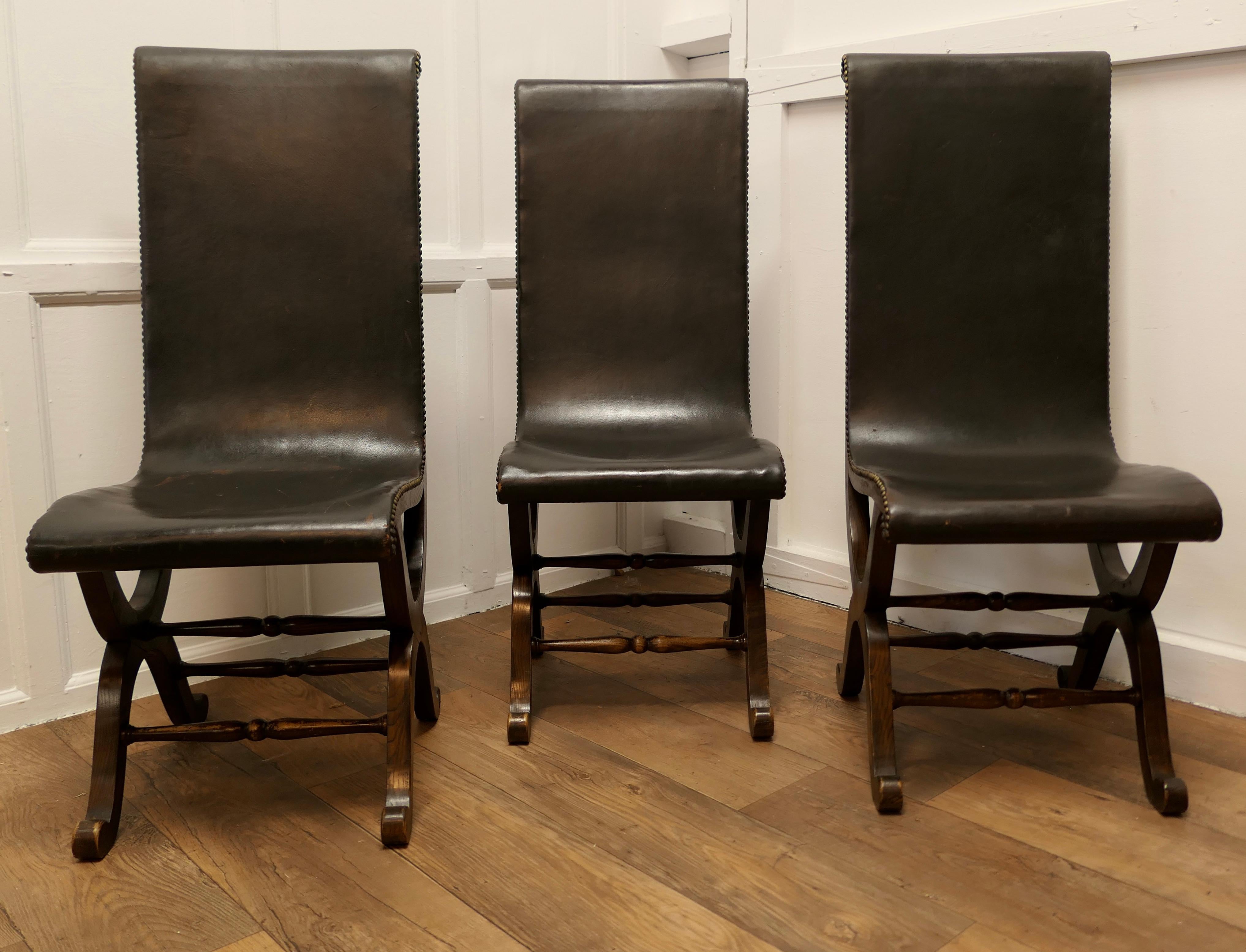 3 Sillas de cuero y roble a juego de Pierre Lottier para chimenea de mediados de siglo 

Un clásico, la Silla Slipper, está fabricada en un magnífico cuero negro suave sobre un armazón clásico neoclásico de roble en X con tachuelas de latón. 
Las
