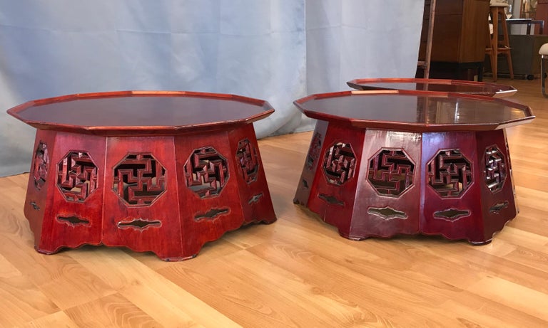 Offered individually are three red lacquer octagon low tables that could also be used as plant stands. We believe they're from the Meiji period. With carved manji symbols around their sides, an ancient religious icon in the cultures of Eurasia.