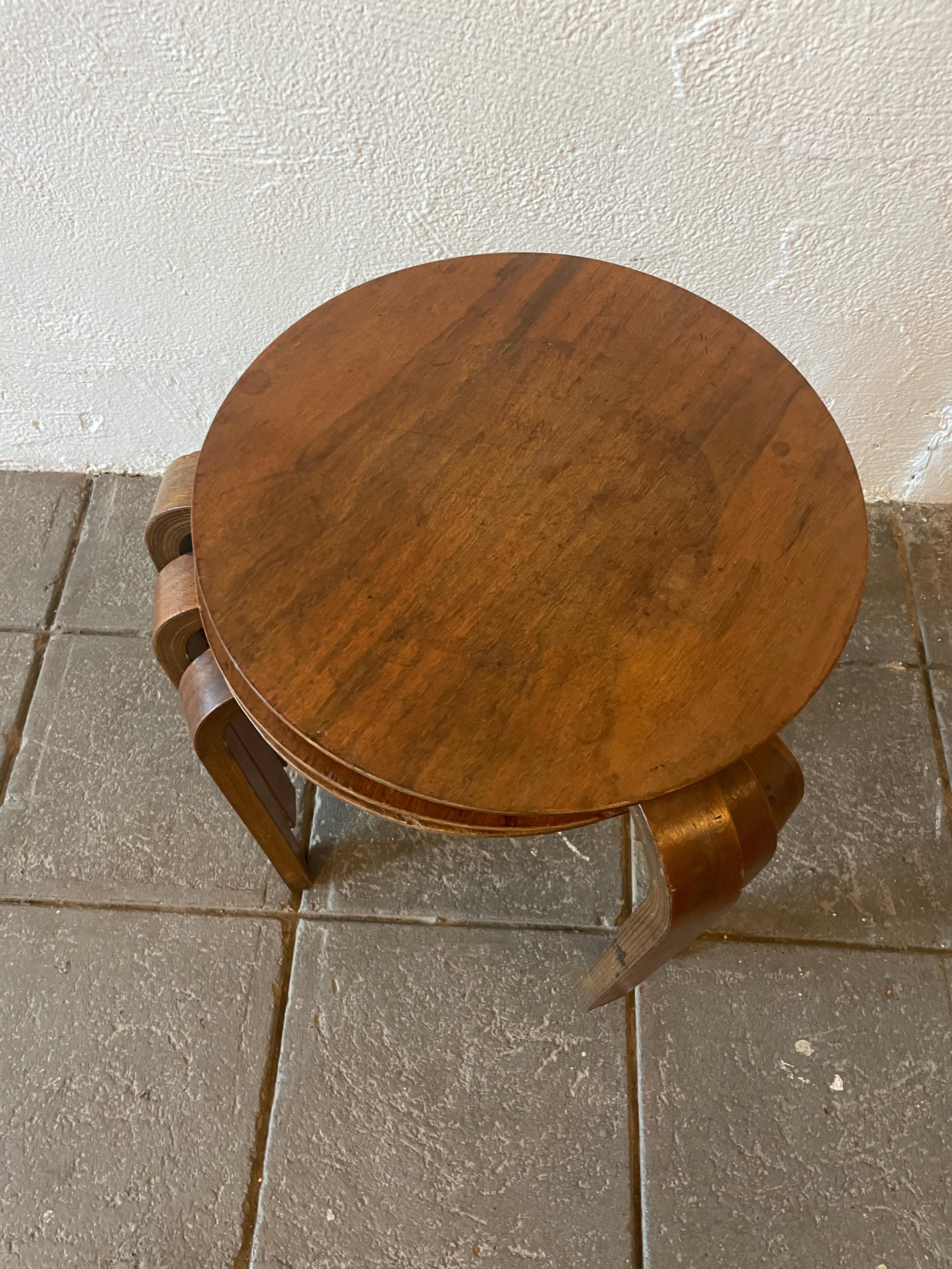 Set of 3 Danish Scandinavian nesting tables or stools. Beautiful bent plywood legs and circular tops showing very little to no use. Medium brown finish with patina. Flat head screws labeled made in Denmark. Set of 3 matching stools or end tables.