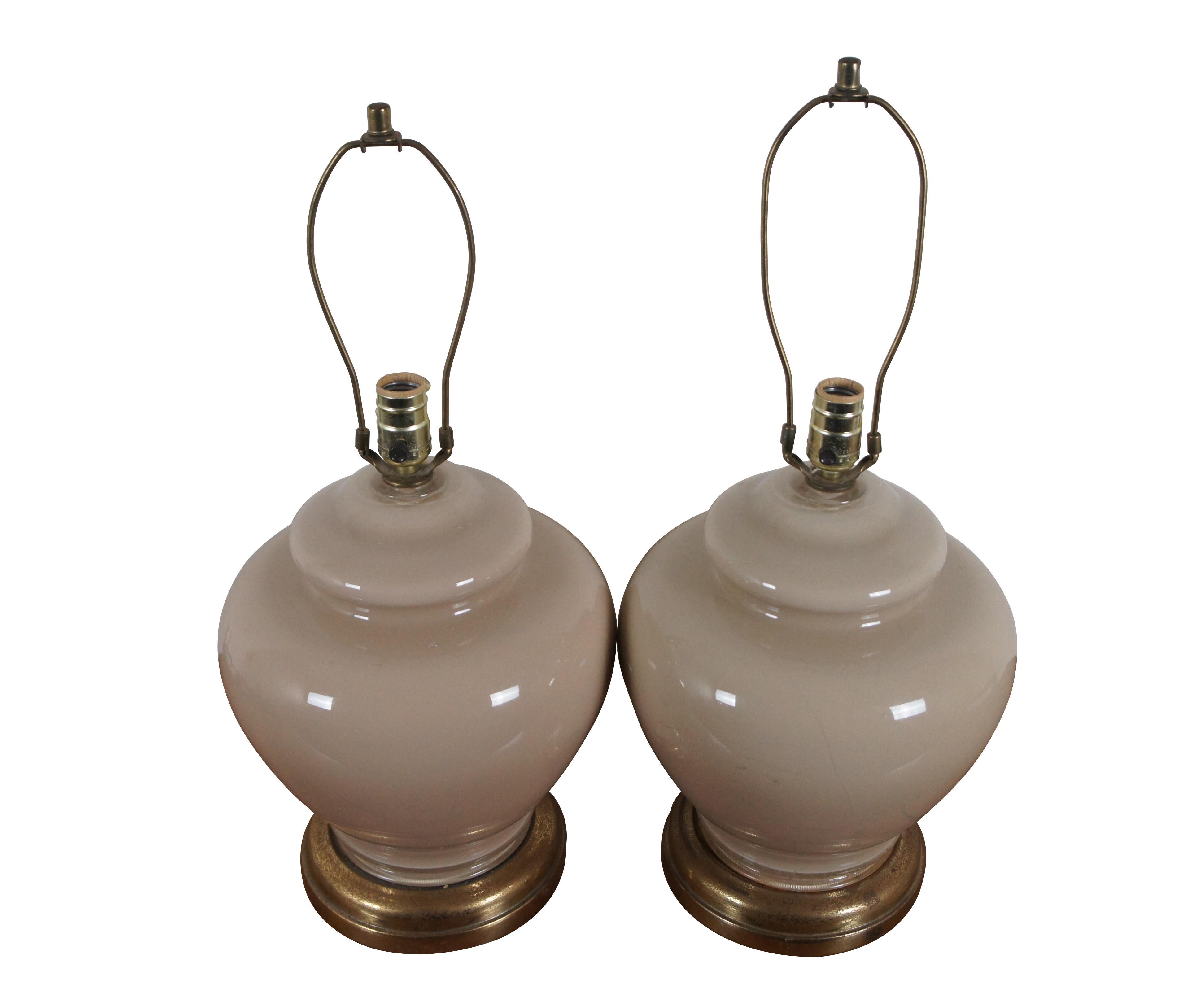 Three mid 20th century glass table lamps featuring a bulbous ginger jar shape, reverse painted a slightly pinkish beige, with brass bases. Includes harps and simple cap shaped finials.

Dimensions:
11.25