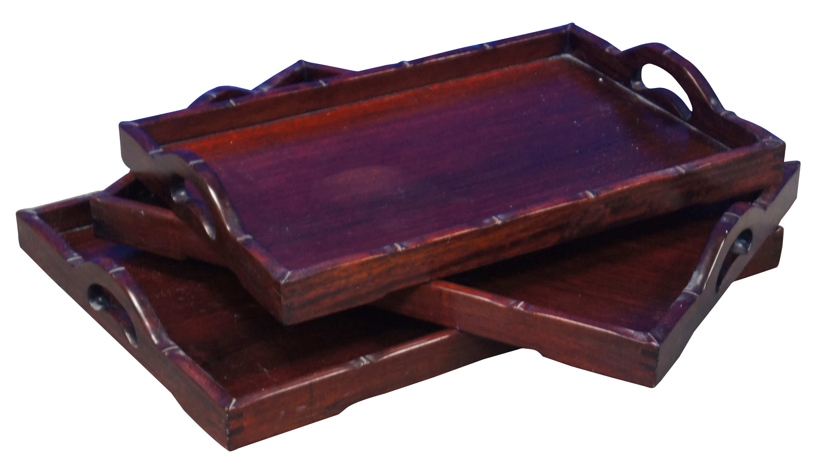 Set of three mid-century rosewood nesting serving bar or tea trays with arched handles and faux bamboo style edge.

Largest - 20” x 14” x 2.25” / smallest - 17.5” x 11.5” x 2.25” (width x depth x height).