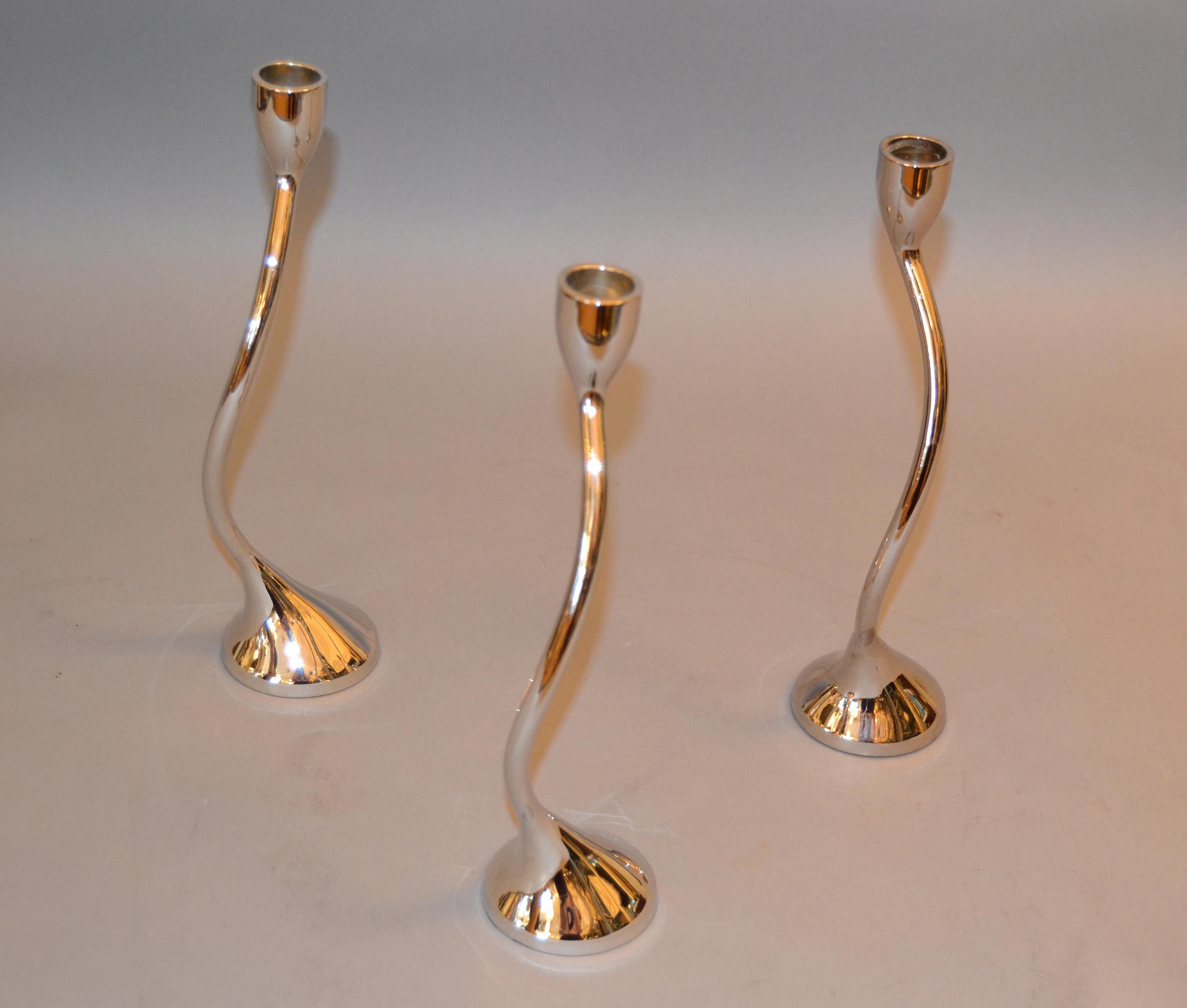 Set of 3 modern silver chrome taper candlestick holders intertwined.
Makers Mark underneath: red ENVELOPE;
They can be arranged in many different ways.
  