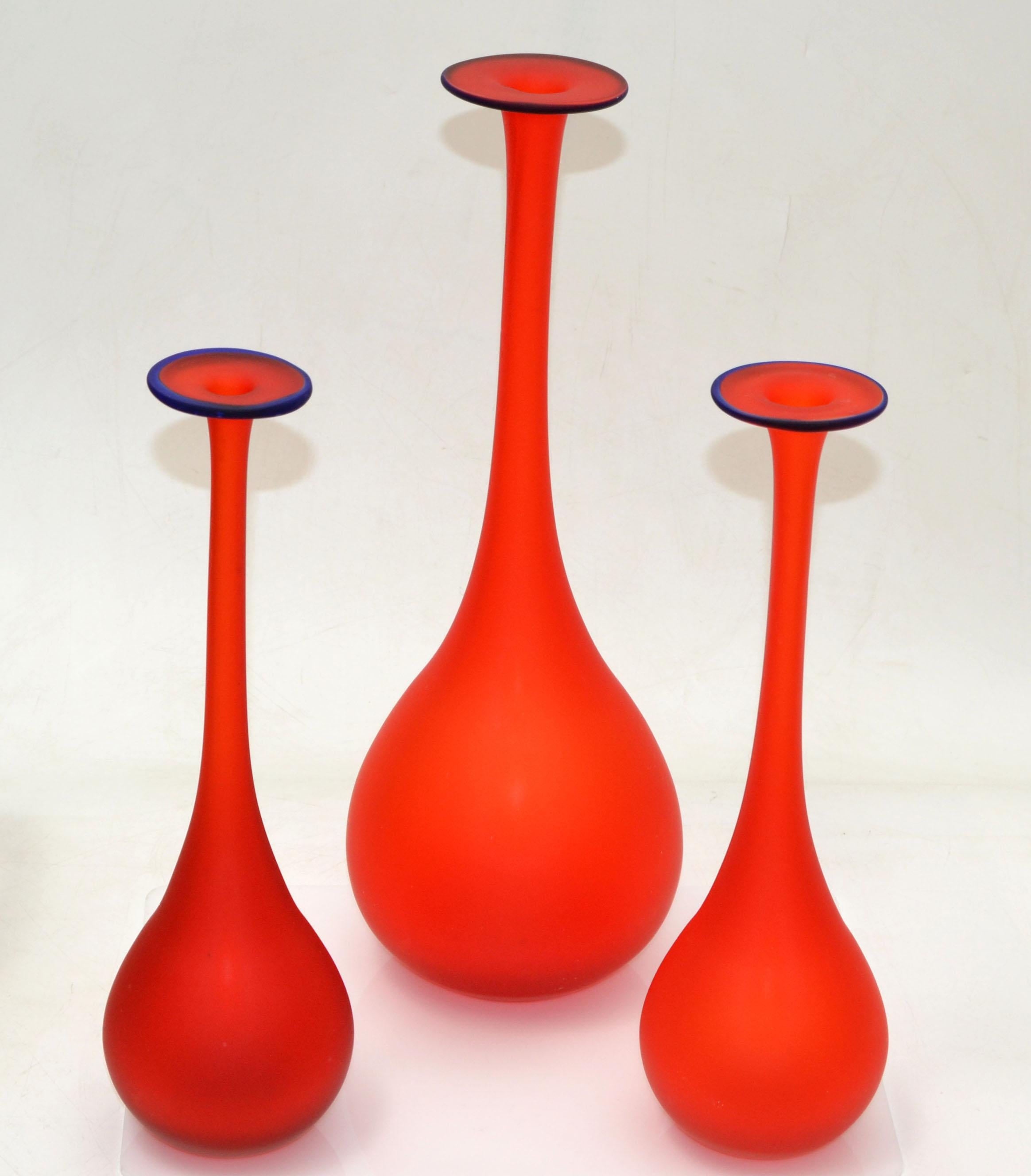 Set of 3 Carlo Moretti Style Mid-Century Modern satin glass bud vases in translucent red with a blue opening.
Nesting Set, the smaller ones are 3.5 inches in diameter, Height 11.5 & 12 inches.
Very beautiful and clean design.

 
