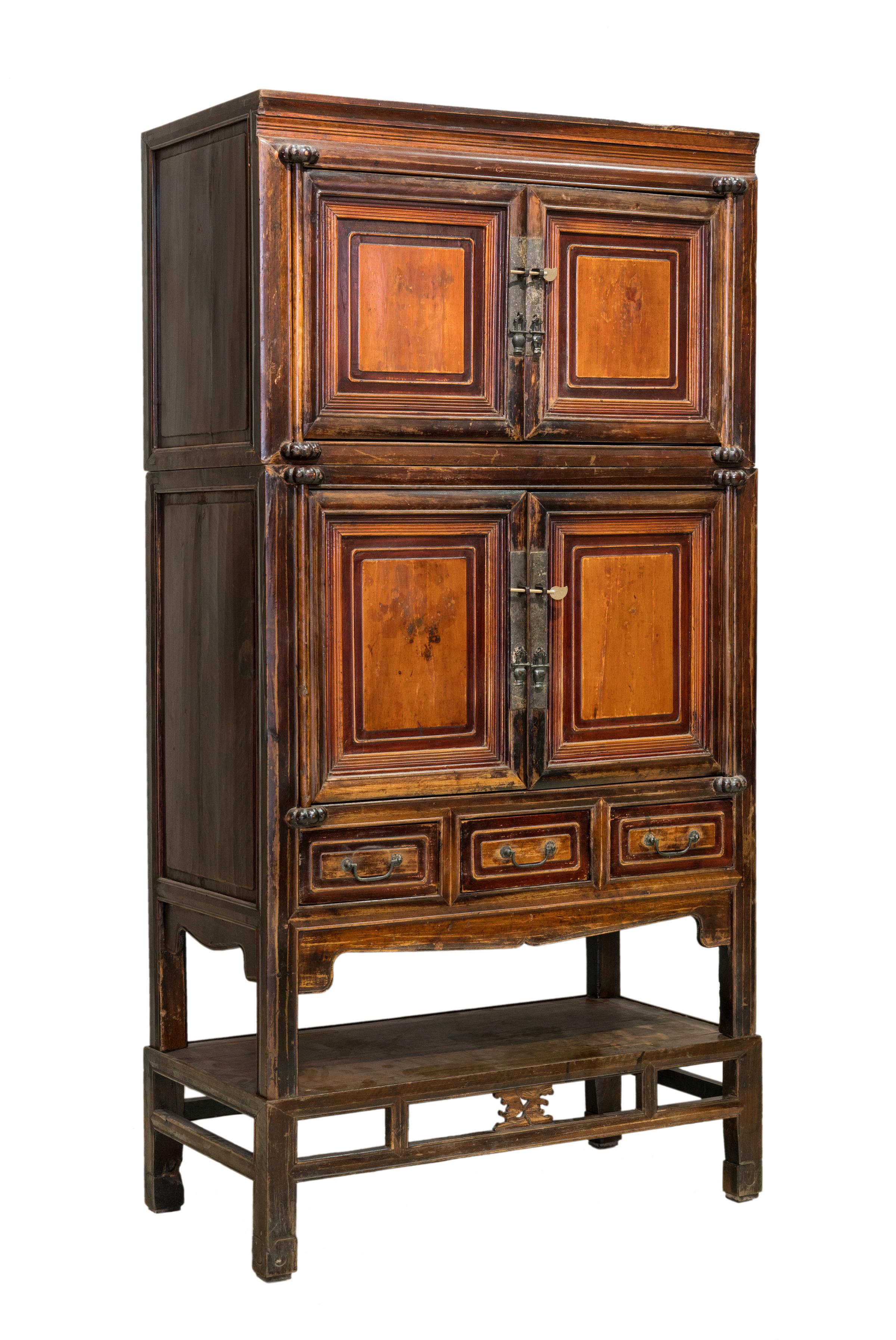 A two-tier cabinet on a stand, from the northern Jiangsu region (commonly called Subei for short), China. This cabinet is made of a combination of elm and fir woods. The traditional wooden hinges are held by very cute pumpkin-shaped holders. It has