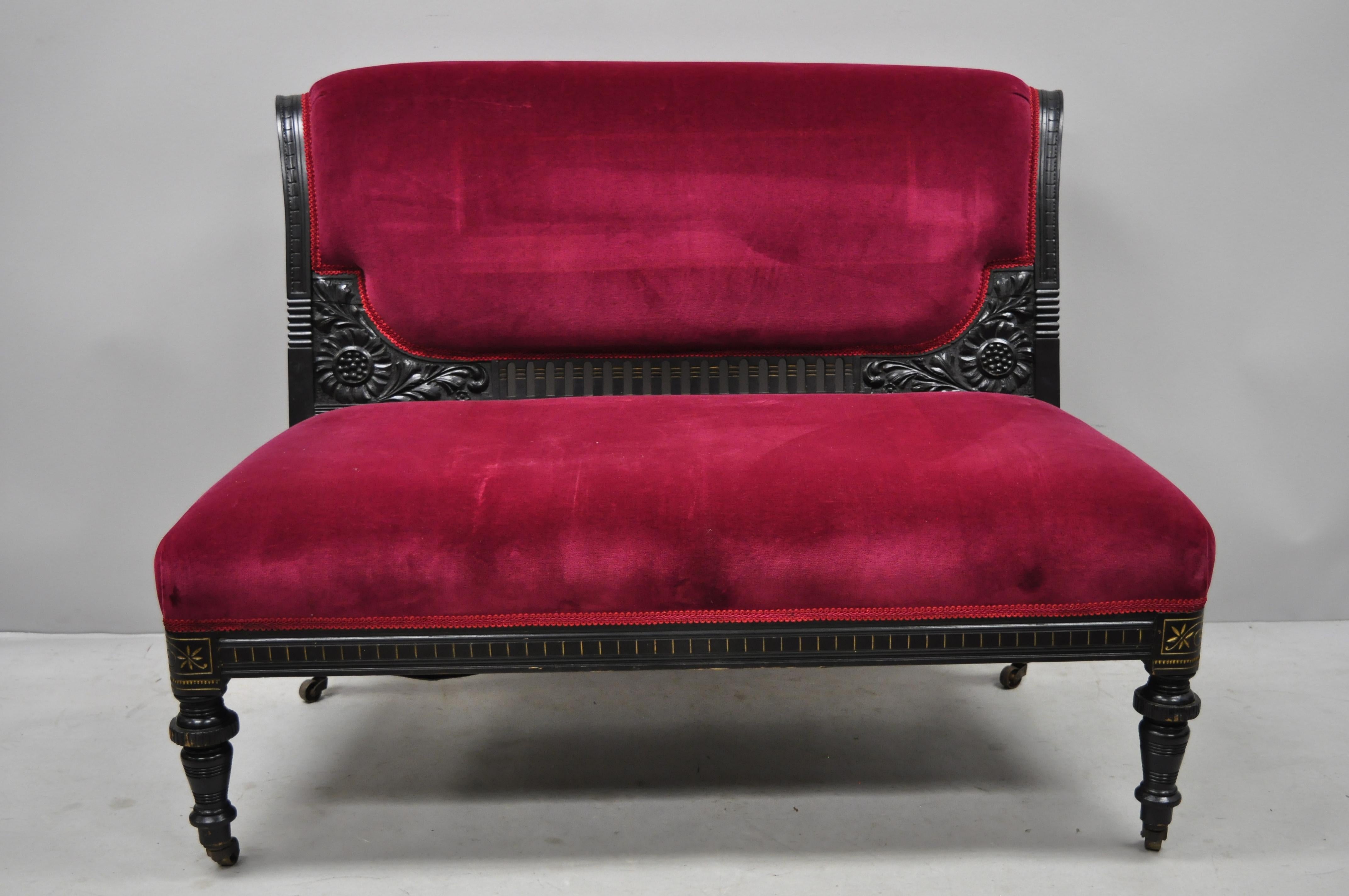 3-piece Eastlake Victorian aesthetic movement ebonized parlor set sofa loveseat chair. Listing features sofa, armless loveseat, side chair, ebonized frames, finely carved details, rolling casters, red velvet upholstery, very nice antique item, circa