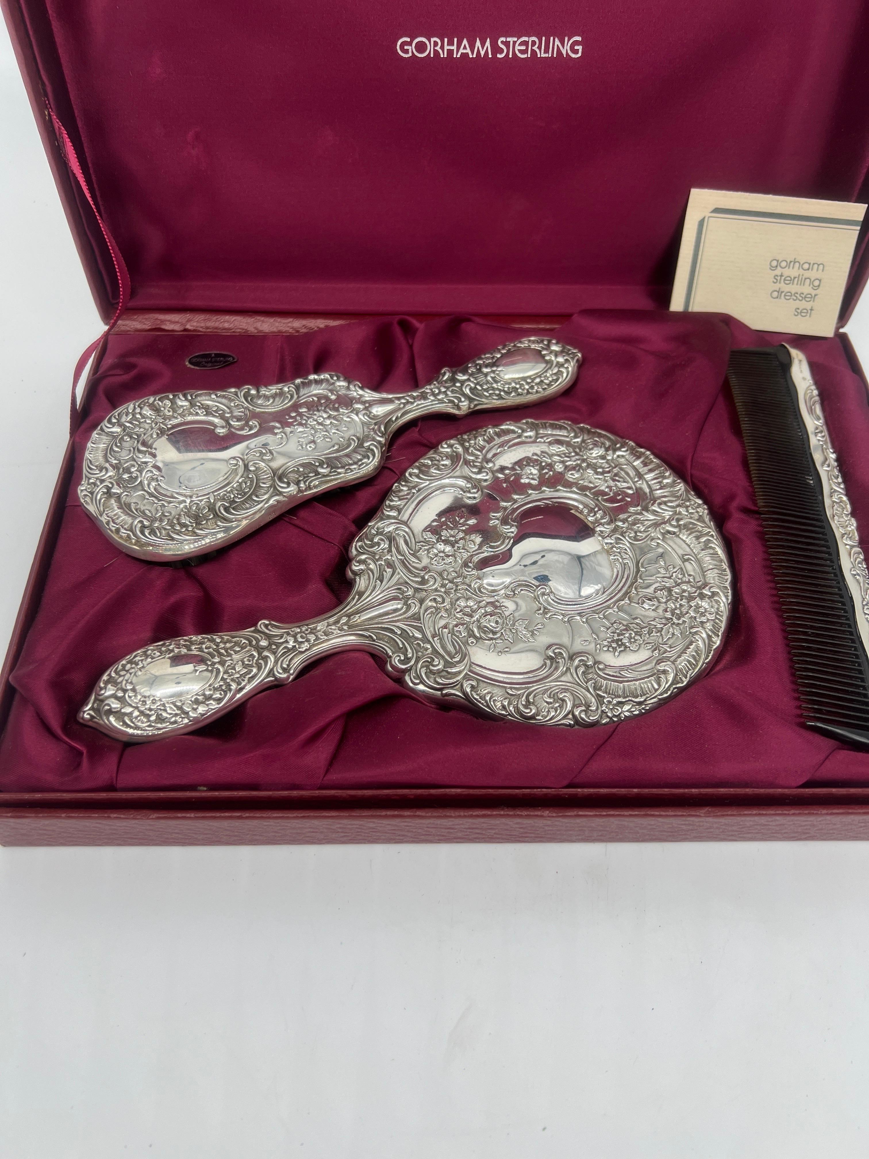 This is a beautiful Gorham Manufacturing Company sterling silver dresser set with its original fitted box. Included is a 3 piece hand mirror, hair brush and comb set - all cast in sterling silver. Each piece is marked appropriately. 