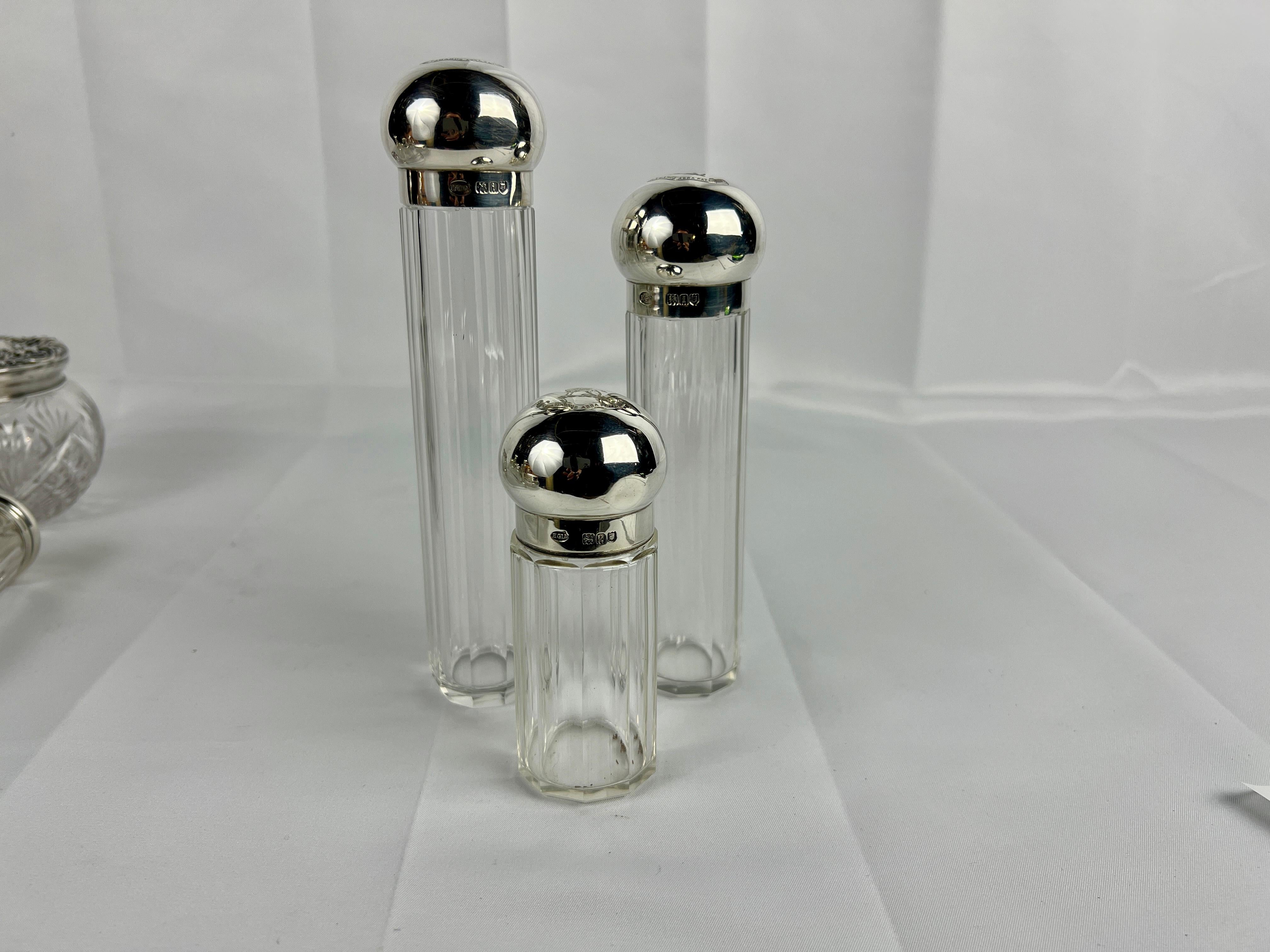 This elegant three-piece dresser jar set, crafted by Henry Greaves, exemplifies the refinement of early 20th-century design. The jars feature cut crystal bodies, showcasing elaborate patterns that reflect light beautifully and highlight the