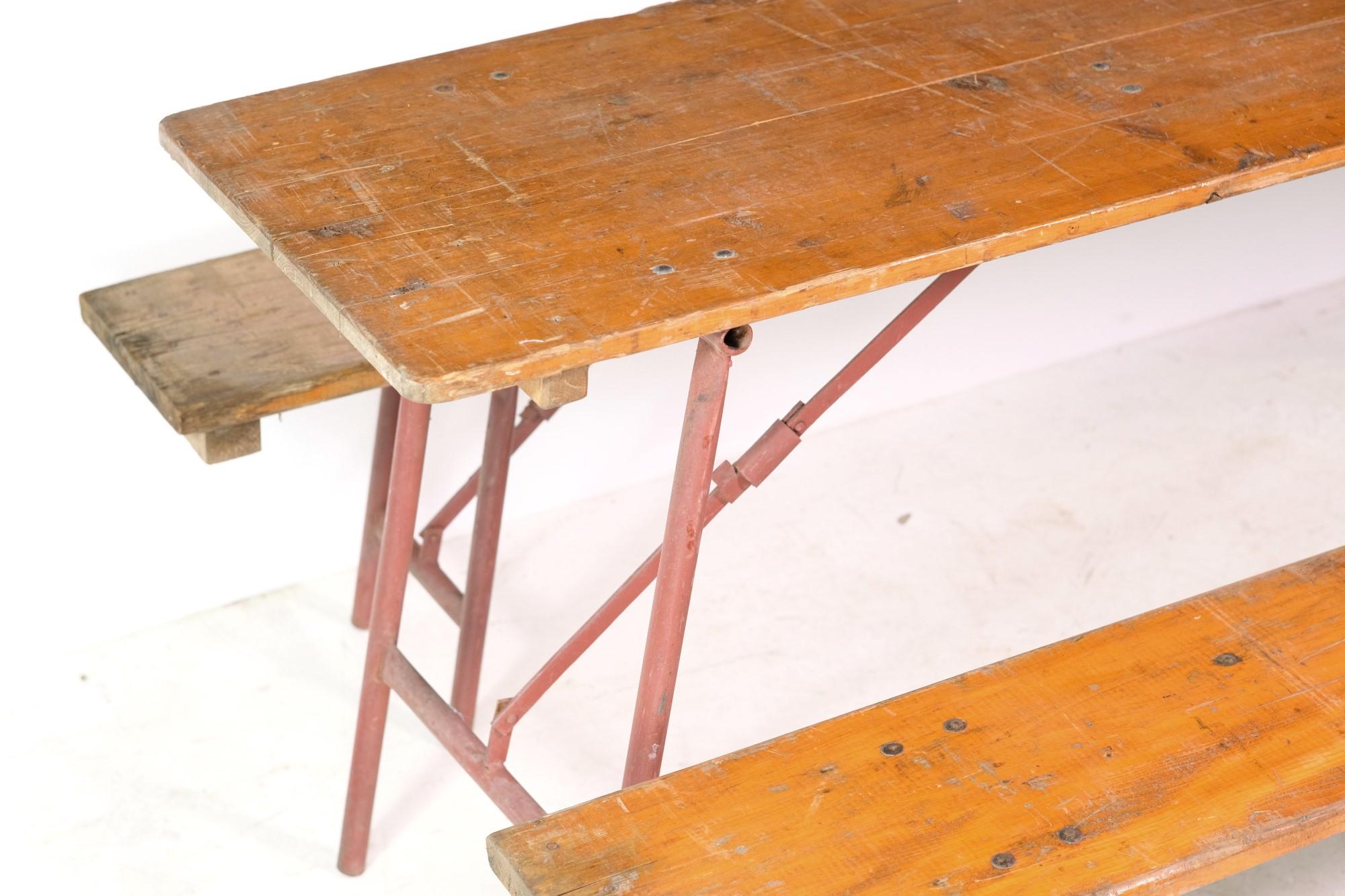 Rare 1900's pine wood 3-pc folding picnic table set. This set comes complete with table and two benches made of pine with red painted metal folding legs. This set is very sturdy and folds very compact for easy storage. One piece is stamped T. SCH.