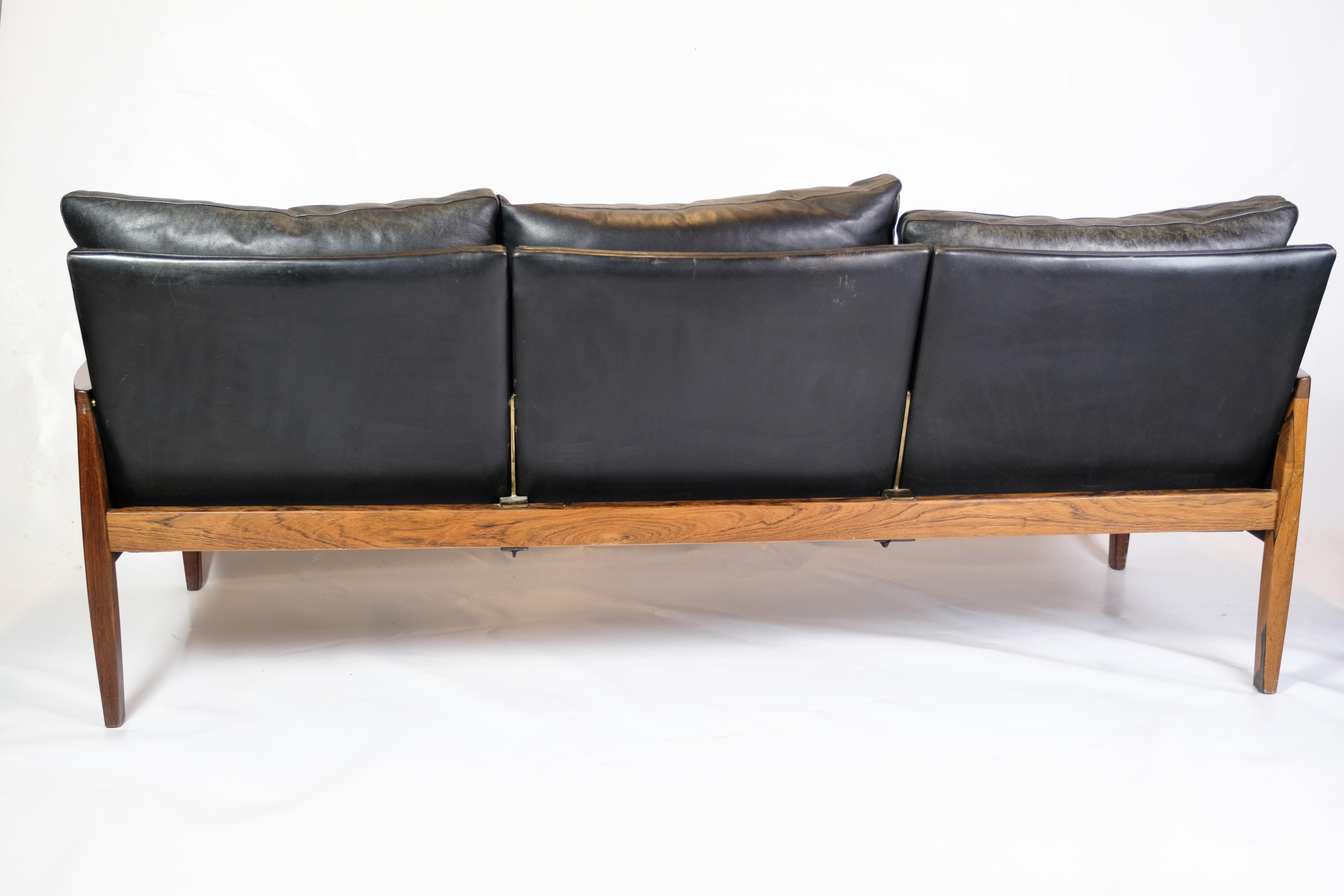 Dieses elegante 3-Sitzer-Sofa verbindet Luxus mit Komfort und Funktionalität. Aus massivem Palisanderholz gefertigt und mit schwarzen Lederkissen gepolstert, bietet dieses Sofa ein anspruchsvolles und komfortables Sitzerlebnis. Die schöne Silhouette