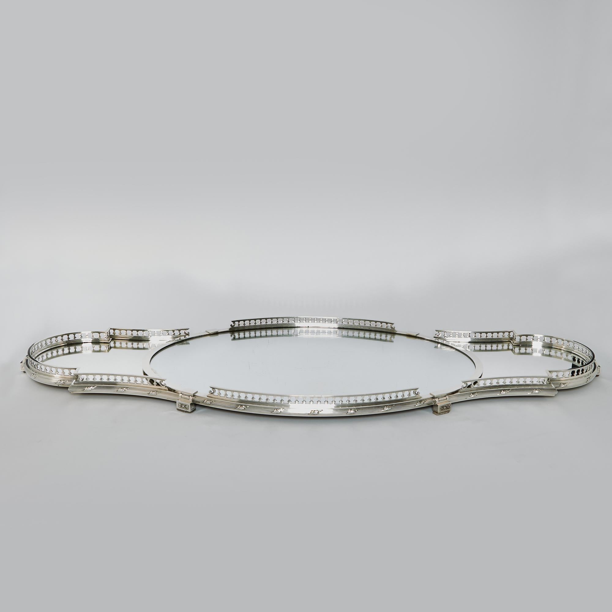 Stunning three-piece mirrored plateau made in French 1st Standard silver (950/1000). The large central oval plateau and two shaped side sections feature raised galleries with baluster supports and a band of ribbon and reed pattern silver decoration