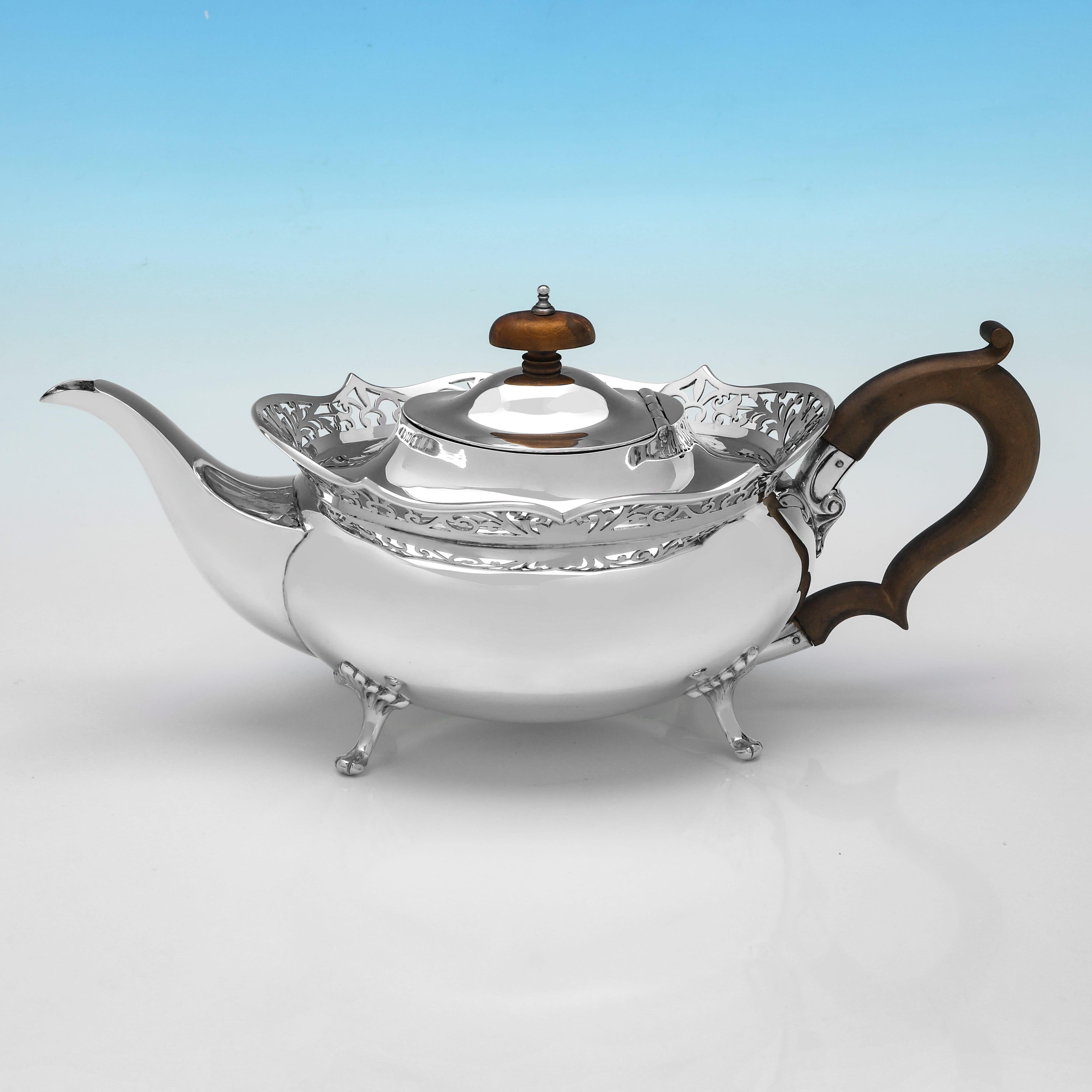 Hallmarked in Birmingham in 1917 by Thomas Edward Atkins, this attractive, George V period, Antique Sterling Silver 3 Piece Tea Set, features pierced detailing around the rims, and each piece stands on 4 cast and applied feet. The set together