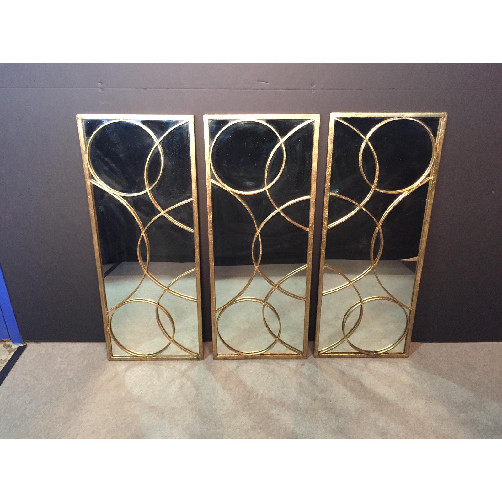 Set of three Arteriors Home gilt iron designer mirrors. Each panel is 18 inches wide. Can be hung horizontally or vertical. Each panel 18” wide.