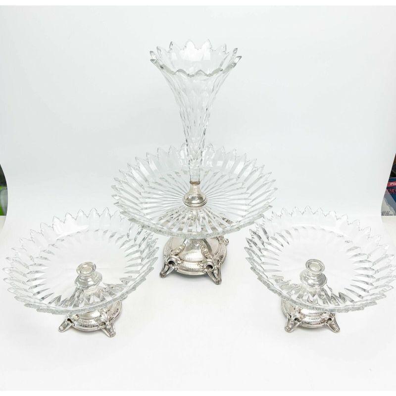 3 Piece Cut Glass Table Garniture & JM van Kempen & Zonen Dutch 833 Silver, 1876.

Set includes epergne and two side compotes. Cut clear glass with pointed edges, silver bases with etched Greek key design and foliate feet. Underside of each with