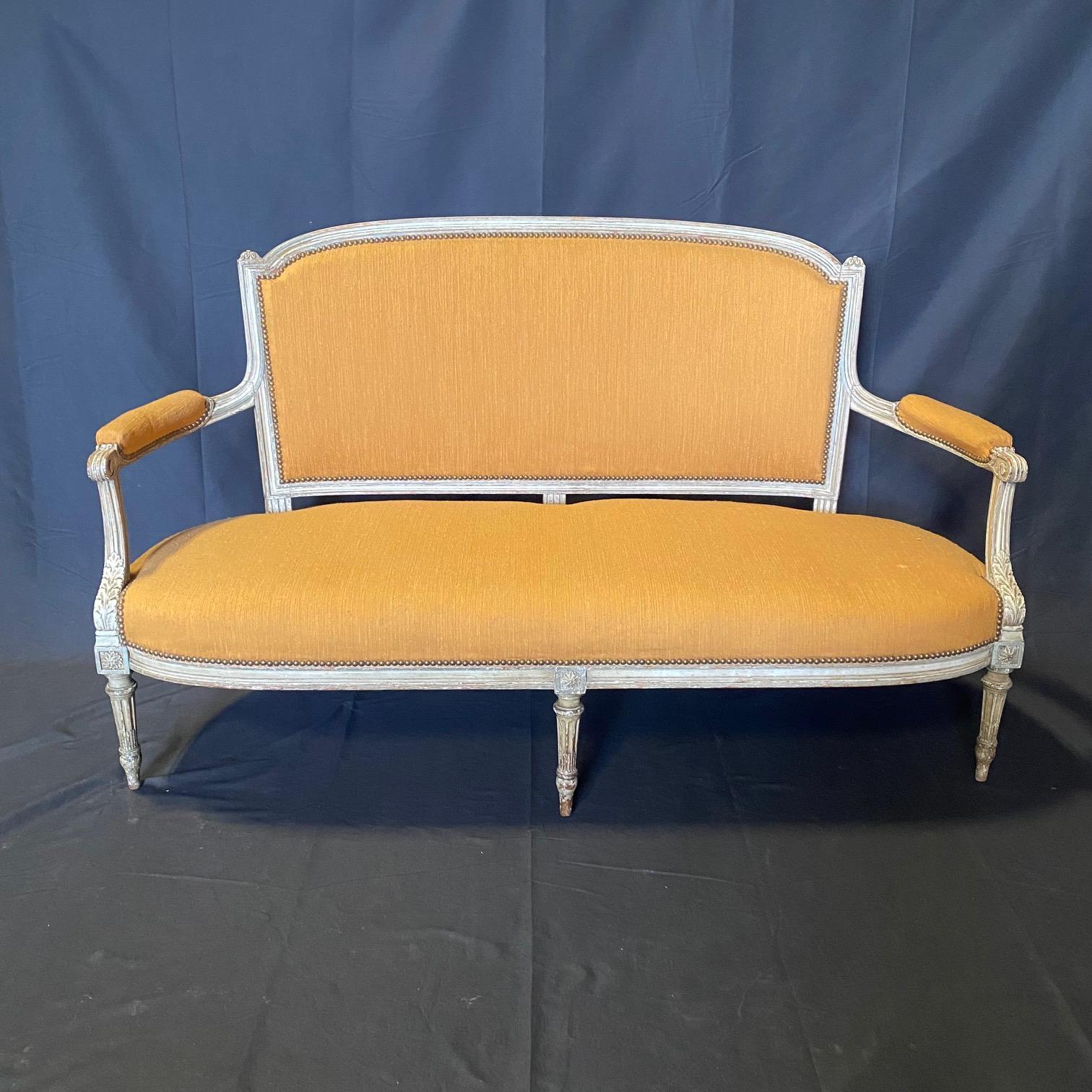 Elegante set da salotto francese Luigi XVI con un divano e una coppia di poltrone, realizzato con cura per aggiungere un tocco di eleganza a qualsiasi spazio abitativo. Il set mette in mostra la bellezza senza tempo dello stile Luigi XVI, noto per i