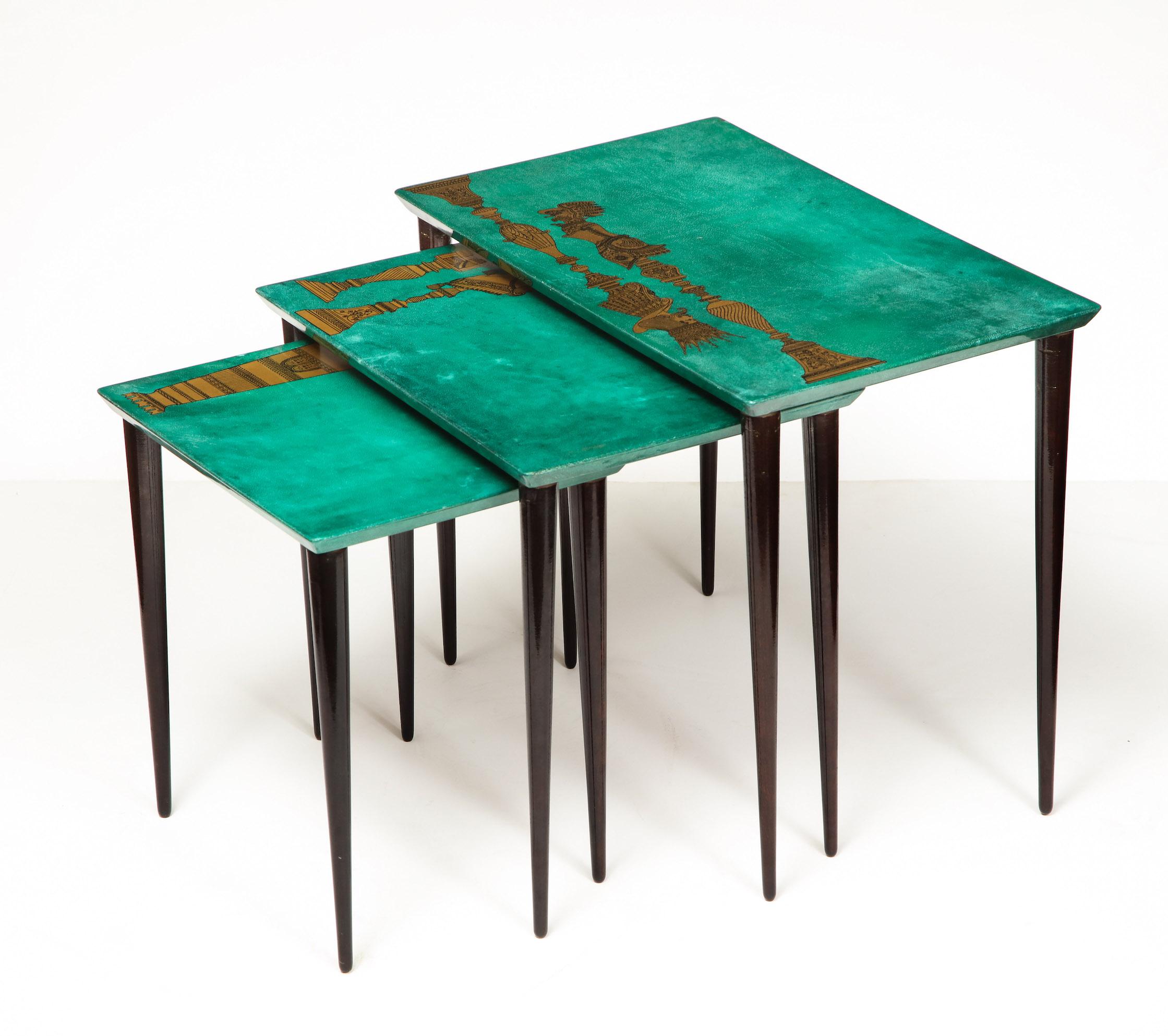 3-piece emerald leather nesting table set by Aldo Tura. Each table top has beautiful chess piece gold print design. The sizes are
20