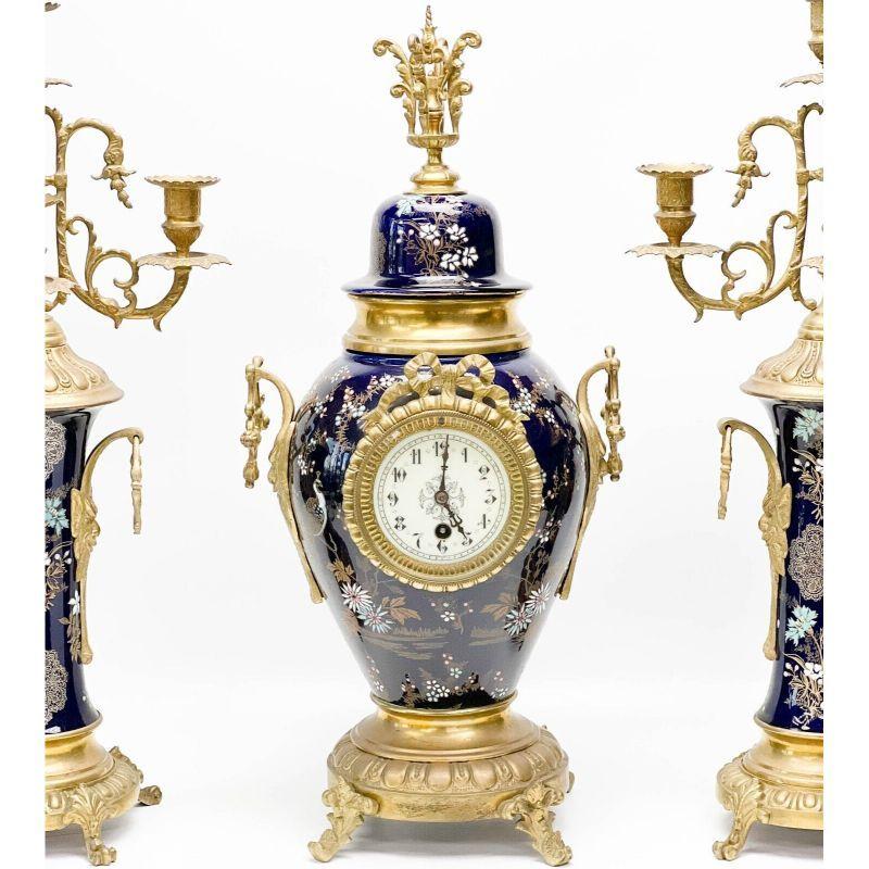 3 Piece French Japonisme gilt bronze Mounted Enameled porcelain clock Garniture

3 Piece French gilt bronze mounted enameled porcelain clock garniture, 1st quarter 20th century. Garniture includes a clock to the center, and a pair of candelabras.