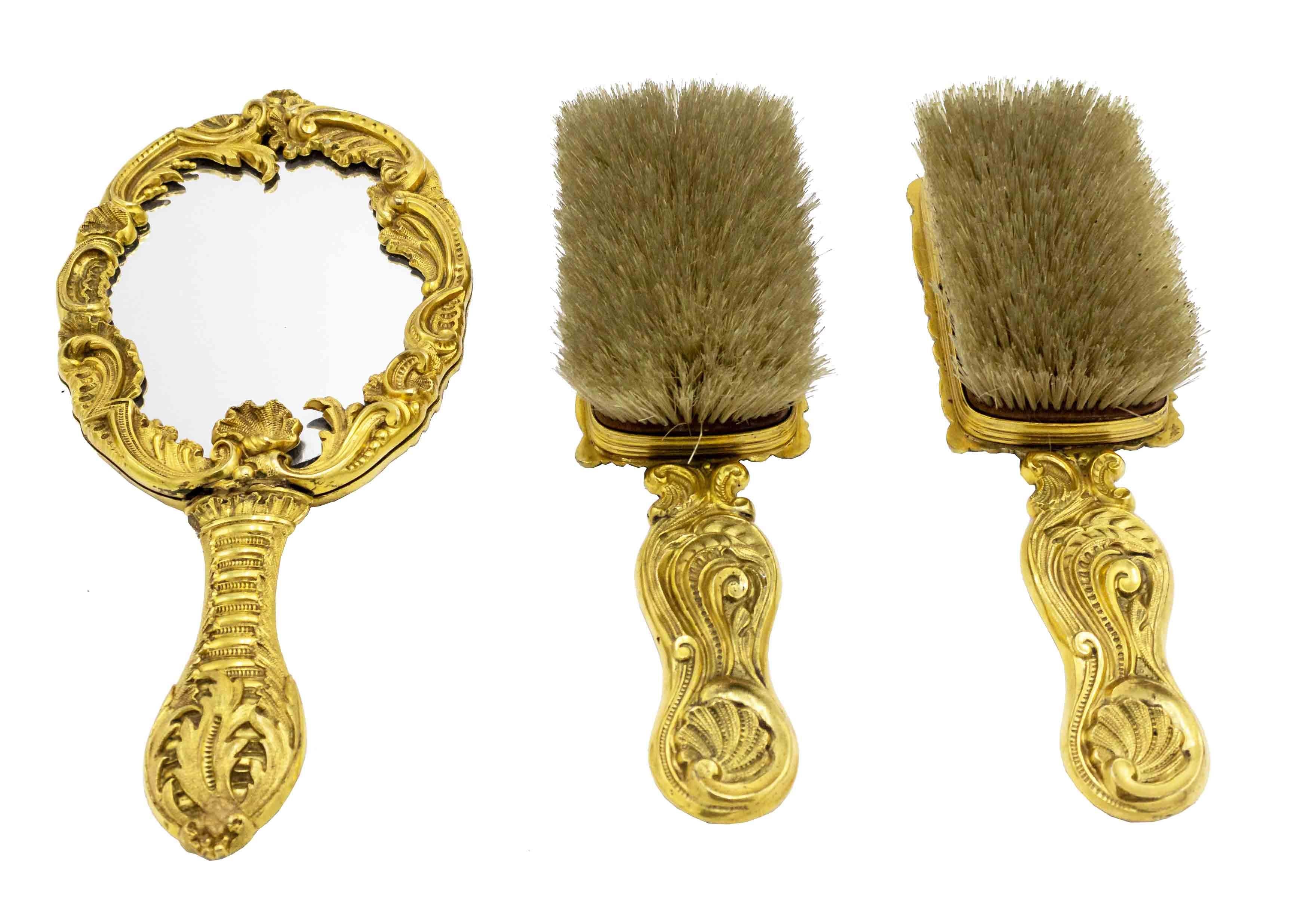 3-Piece French Louis XV style (19th cent) bronze dore vanity set composed of 2 brushes and 1 hand mirror with handles (priced as set).
 