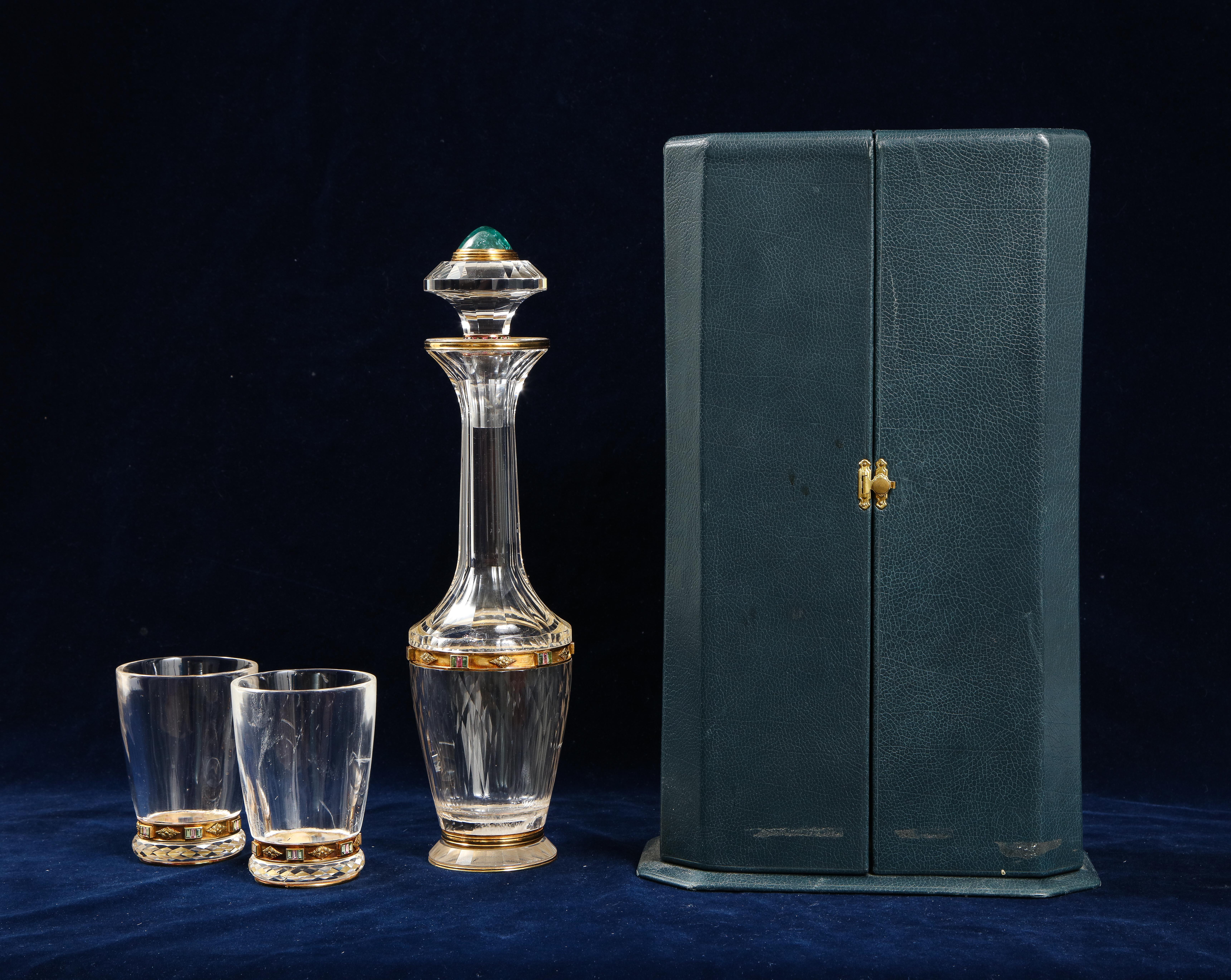 Un Impresionante, Único y Bastante Inusual Juego de Tres Piezas de Decantador y Vaso de Cristal de Roca Tallado a Mano, Montado en Oro y Joyas, en su Estuche Original.  El juego incluye un decantador, un tapón y dos vasos.  Se trata de un auténtico