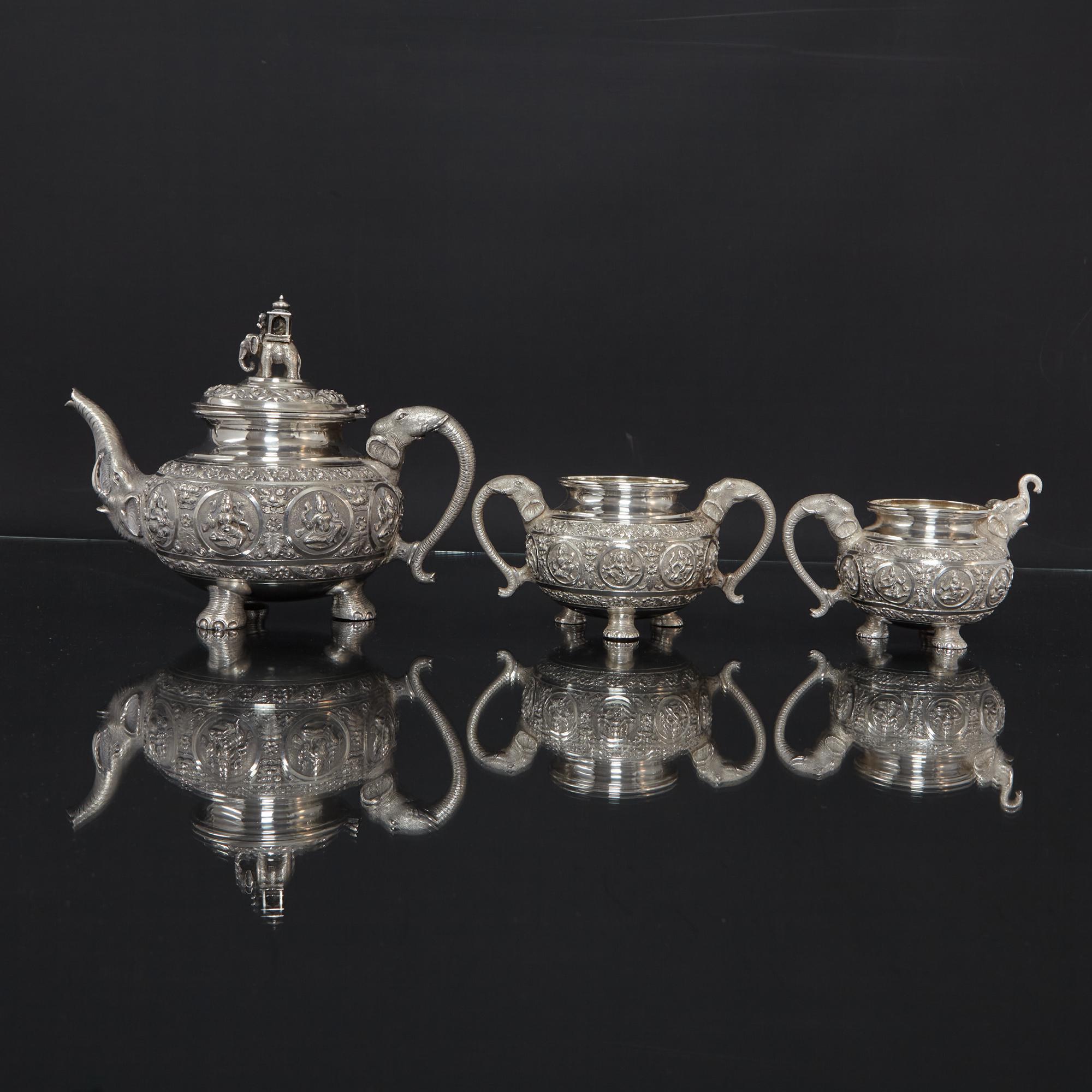 Delightful and decorative three-piece Indian silver tea set of exceptional quality. Each piece is heavily hand-chased in the finest detail, featuring panels with various deities, foliage and floral designs.

Applied, hand-chased castings include the