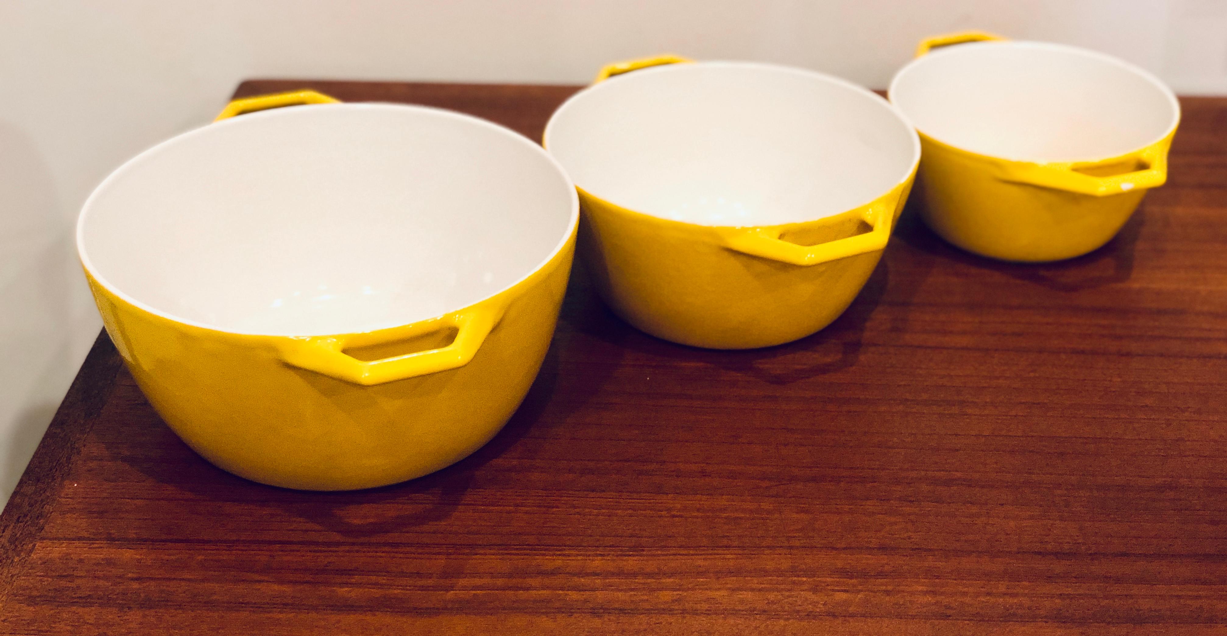 Beautiful 3-piece nesting set of cookware cast-iron enameled in yellow color very nice and clean condition, circa 1960s. The small one has a tiny chip on the handle and shows a bit more wear than the others 7