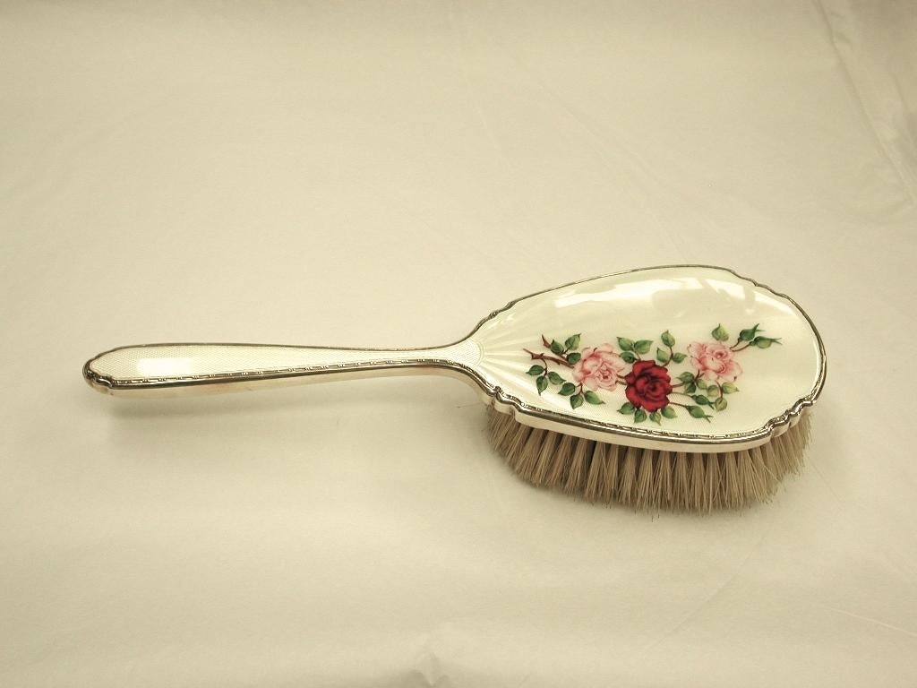 3-piece silver ladies dressing table set, comprising of a hand mirror, hairbrush and clothes brush.
Made by W G Sothers of Birmingham using real bristle, which is in very good condition.
Wonderful enameling with realistic roses, leafwork and buds.