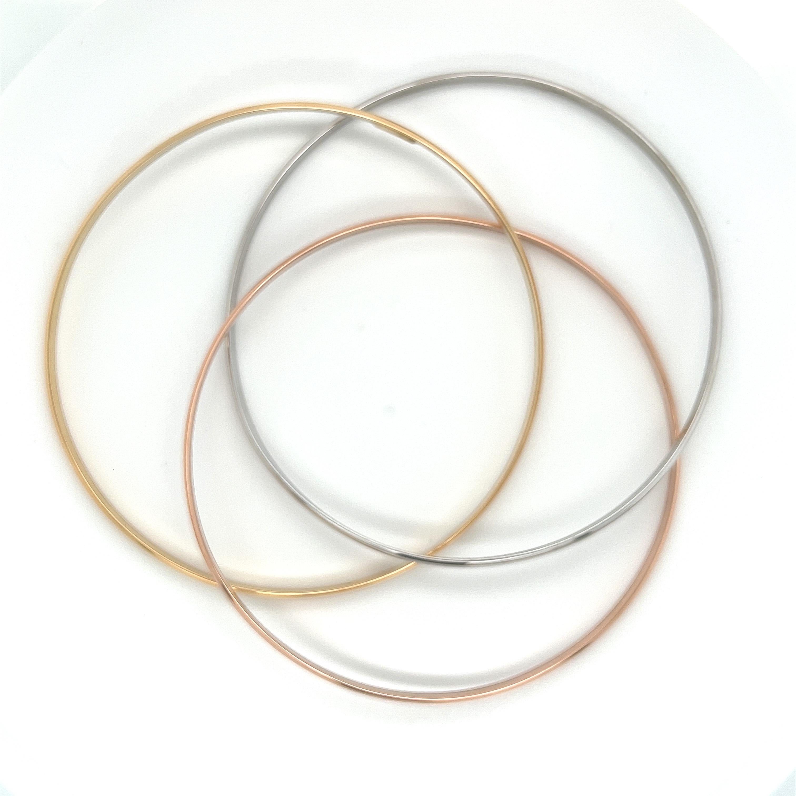 3 piece, tri-color bangle in 18 karat gold. Rose, yellow, and white gold welded in unison to create a gorgeous and classic bangle. This bangle is made in 18k solid gold with a protective double rhodium plating for long-lasting shine. Polished finish