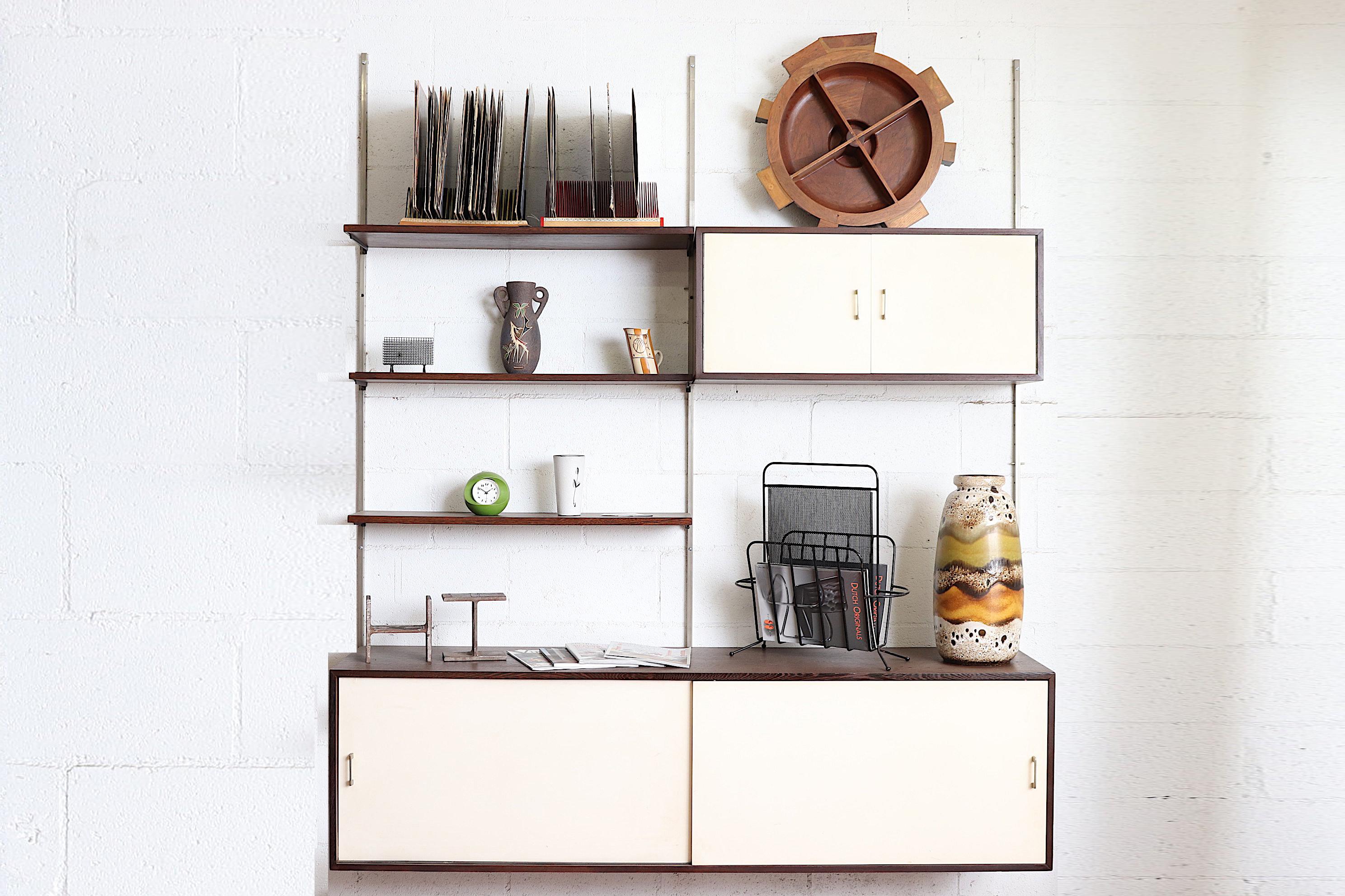 Very cool mid-century wall-mounted shelving unit. 3 wenge cabinets with off-white Formica doors and 3 wenge shelves. All pieces are moveable and can be arranged any way to suit your needs. Metal wall mounts. Lightly refinished but in otherwise good