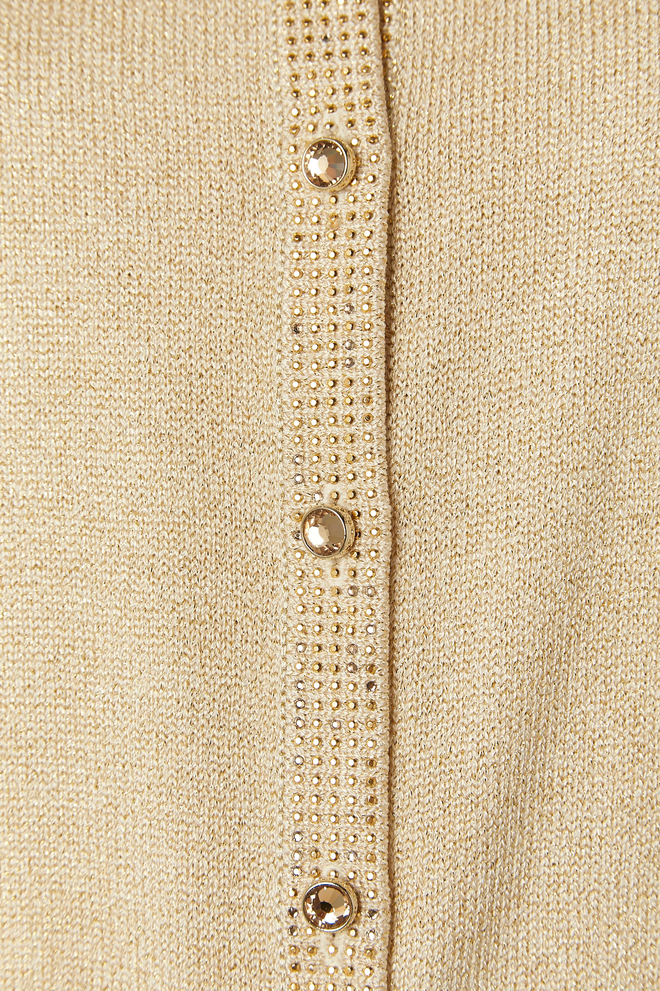 3 pieces ensemble ( cardigan, top and skirt) in knit with pattern made of mini studs. 
Knit composition: 51% wool, 45% rayon, 4% metallized polyester. 
Buttons and buttonhole closure in the middle front and shoulder-pads. 
SIZE of the jacket and