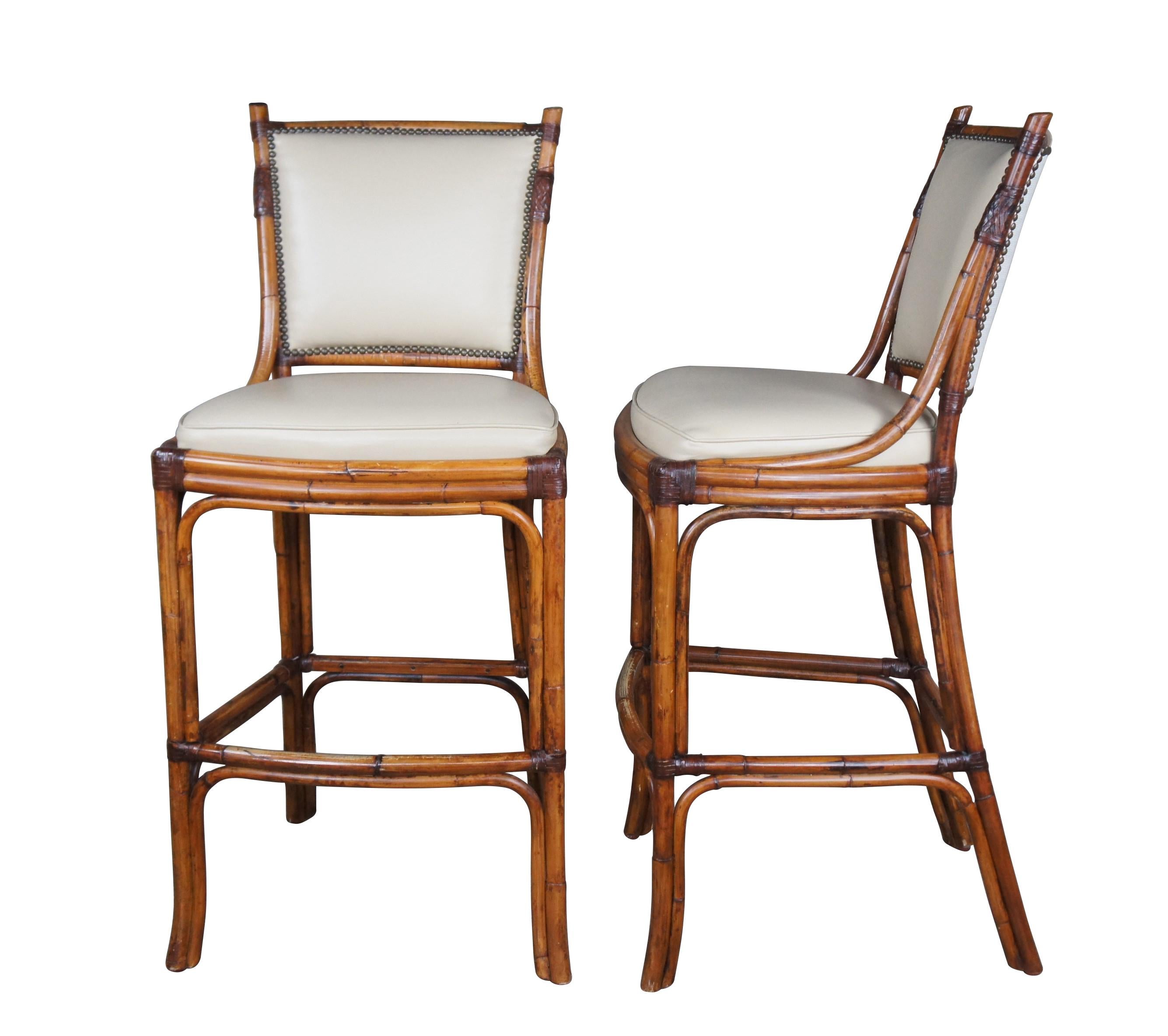Vintage set of three Pierce Martin barstools featuring faux bamboo and rattan frame with foot rest, leather seat, nailhead trim and linen back.

Atlanta-based, PierceMartin is continuously setting new standards as a 