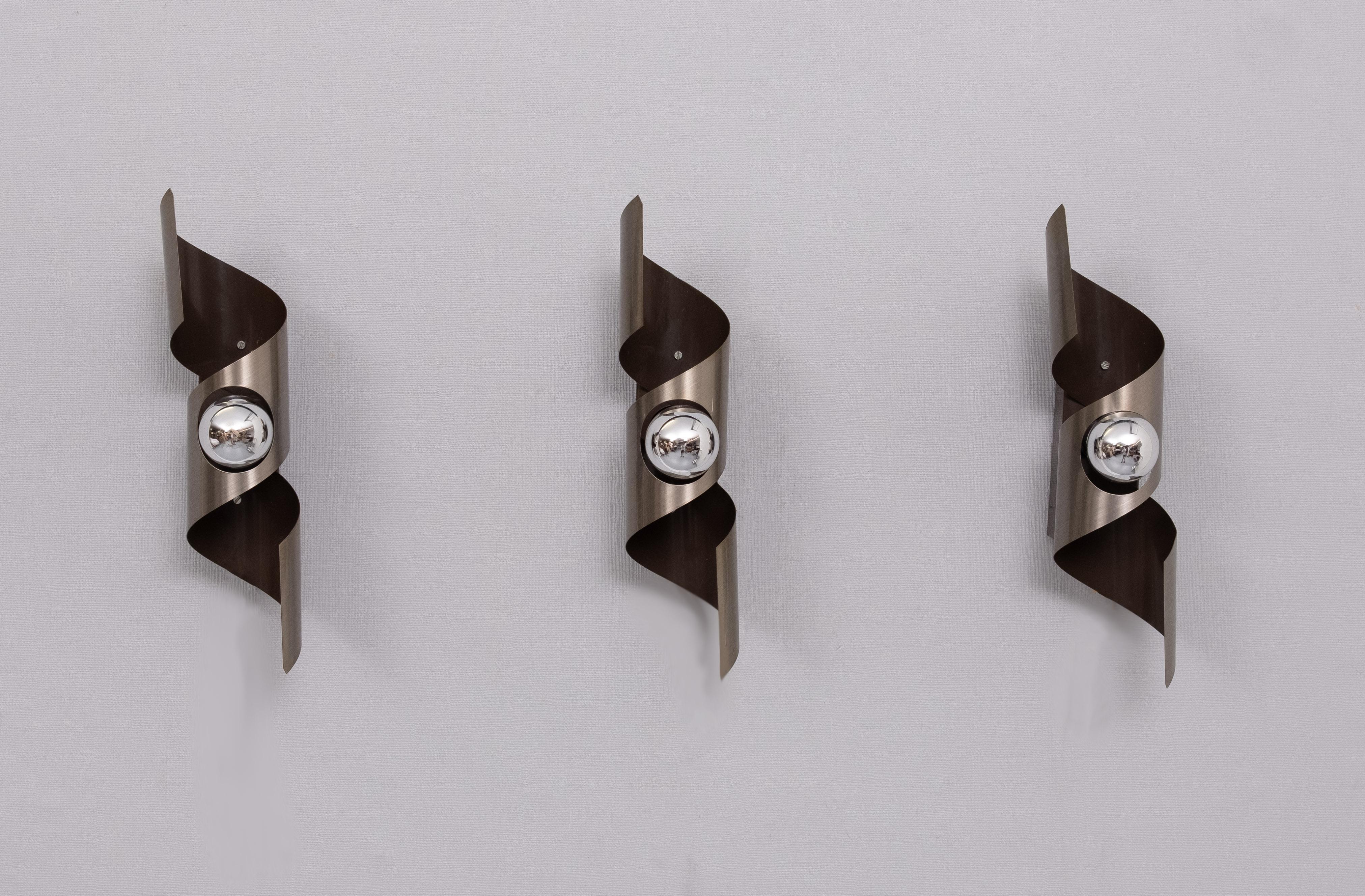set of Three Space Ace style ,Wall Sconces .Mocha Brown color .
with aluminum . model  ''Wokkel'' attributed to Raak Amsterdam .
1970s    Small E14 socket needed.  Very nice light effect when lit .