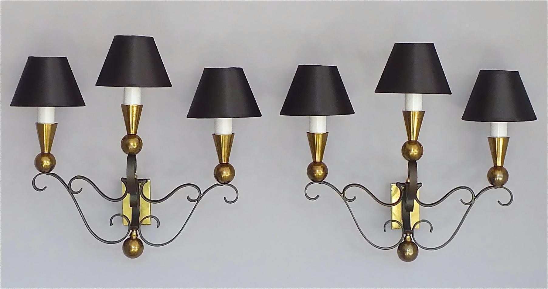 Amazing and rare set of three french Gilbert Poillerat or Jacques Adnet Style wall lights, France around 1940s to 1950s. Two large 3-arm sconces measure each 46 cm / 18.11 inches wide, 42 cm / 16.54 inches tall and 23 cm / 9.06 inches deep, one