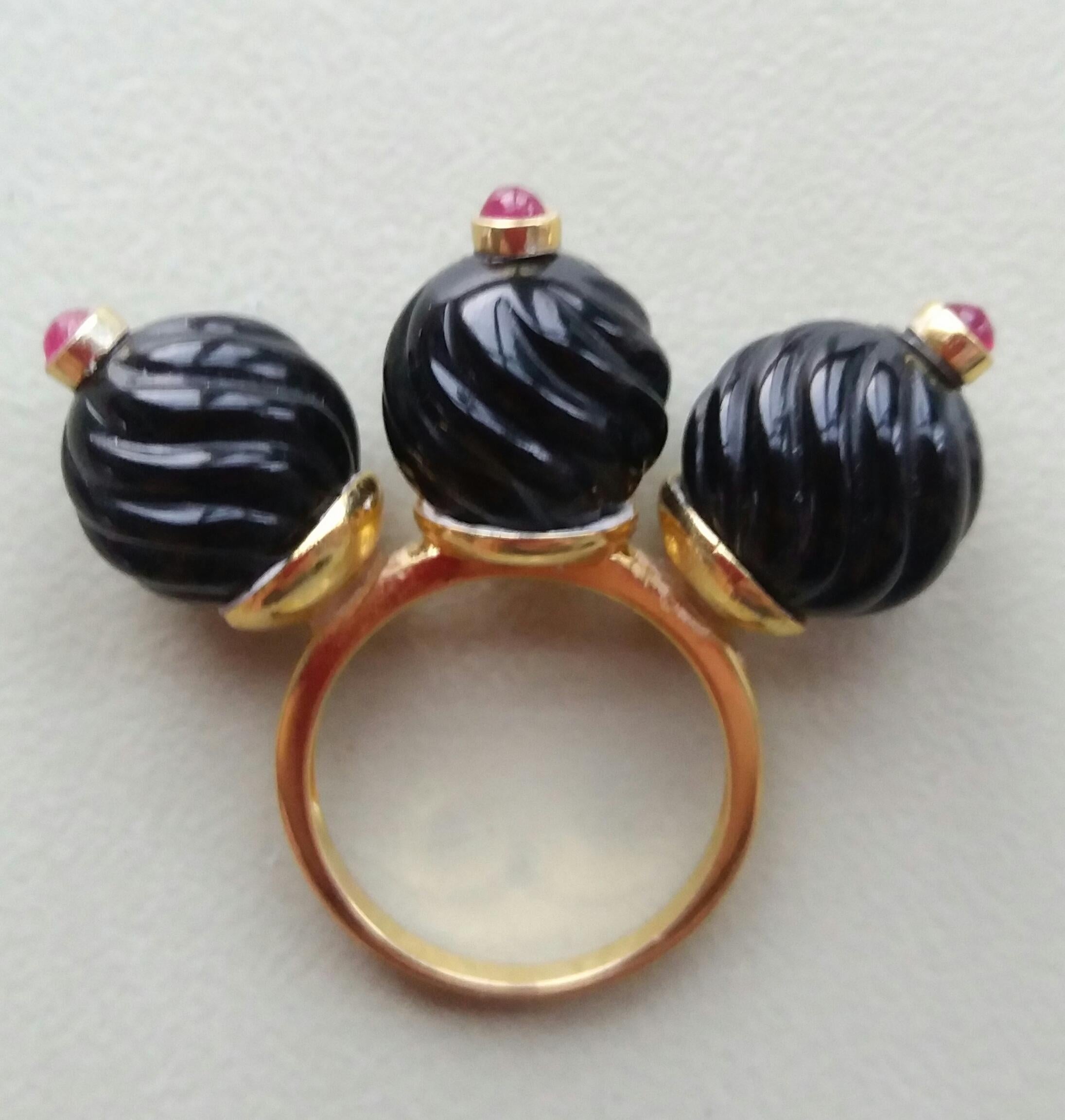 Unique and Classic Cocktail Ring composed of 3 engraved Black Onyx spheres of 12 mm. in diameter surmounted by 3 small Ruby cabochons set in yellow gold bezels,all set on a 3 cup yellow gold shank.
In 1978 our workshop started in Italy to make