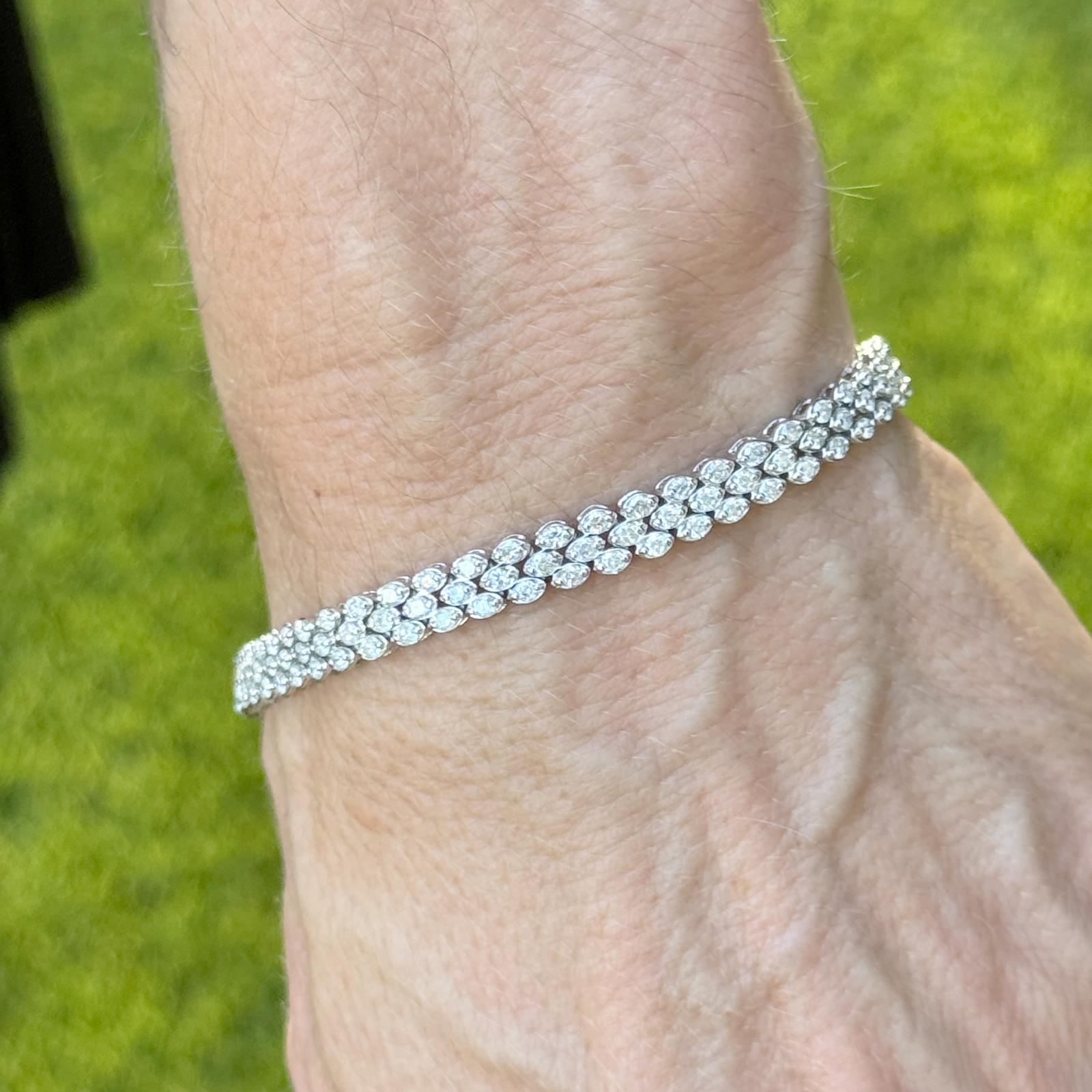 Elegante bracciale a tre file di diamanti in oro bianco 14K, con 159 diamanti rotondi taglio brillante per un totale di circa 3,50 carati, di colore I e purezza SI2. Il bracciale misura 7,25 pollici di lunghezza e 0,25 pollici di larghezza, pesa 8,5