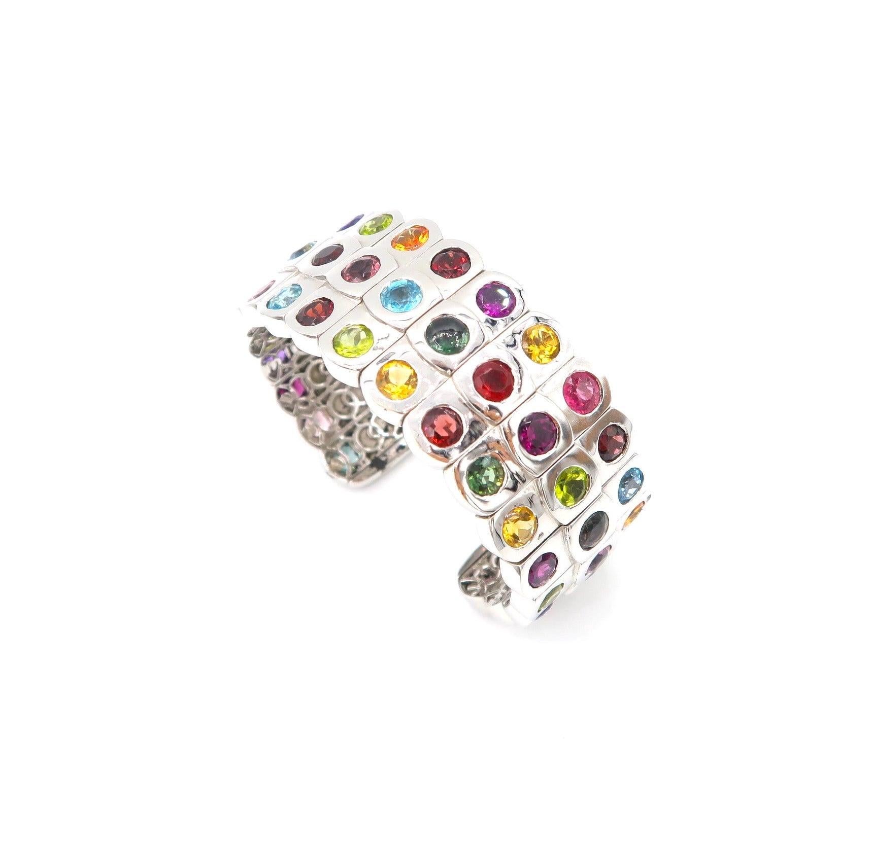 3-Row Multicolor Semi Precious Gemstone Open Bangle Cuff in 18K White Gold 

Gold: 18K White Gold, 109.74 g
Multicolour Gemstones: Peridot, Tourmaline, Aquamarine, Amethyst, Rhodolite, Citrine, 35.13 total carat

