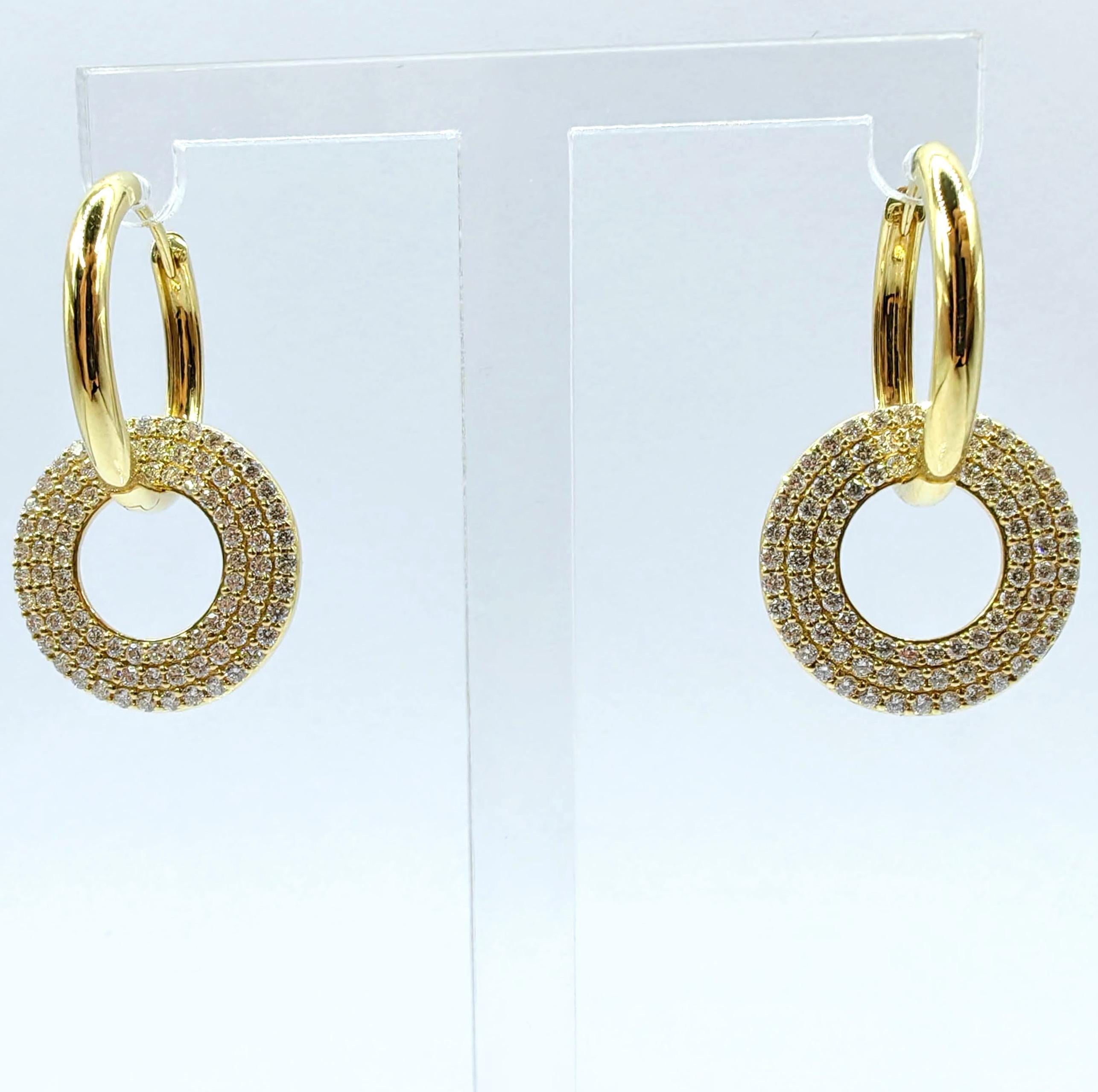 Une géométrie sophistiquée rencontre un éclat brillant dans ces exquises boucles d'oreilles circulaires en forme de goutte. Réalisée en or jaune 18 carats lustré, chaque boucle d'oreille présente un superbe pendentif circulaire orné de trois rangées